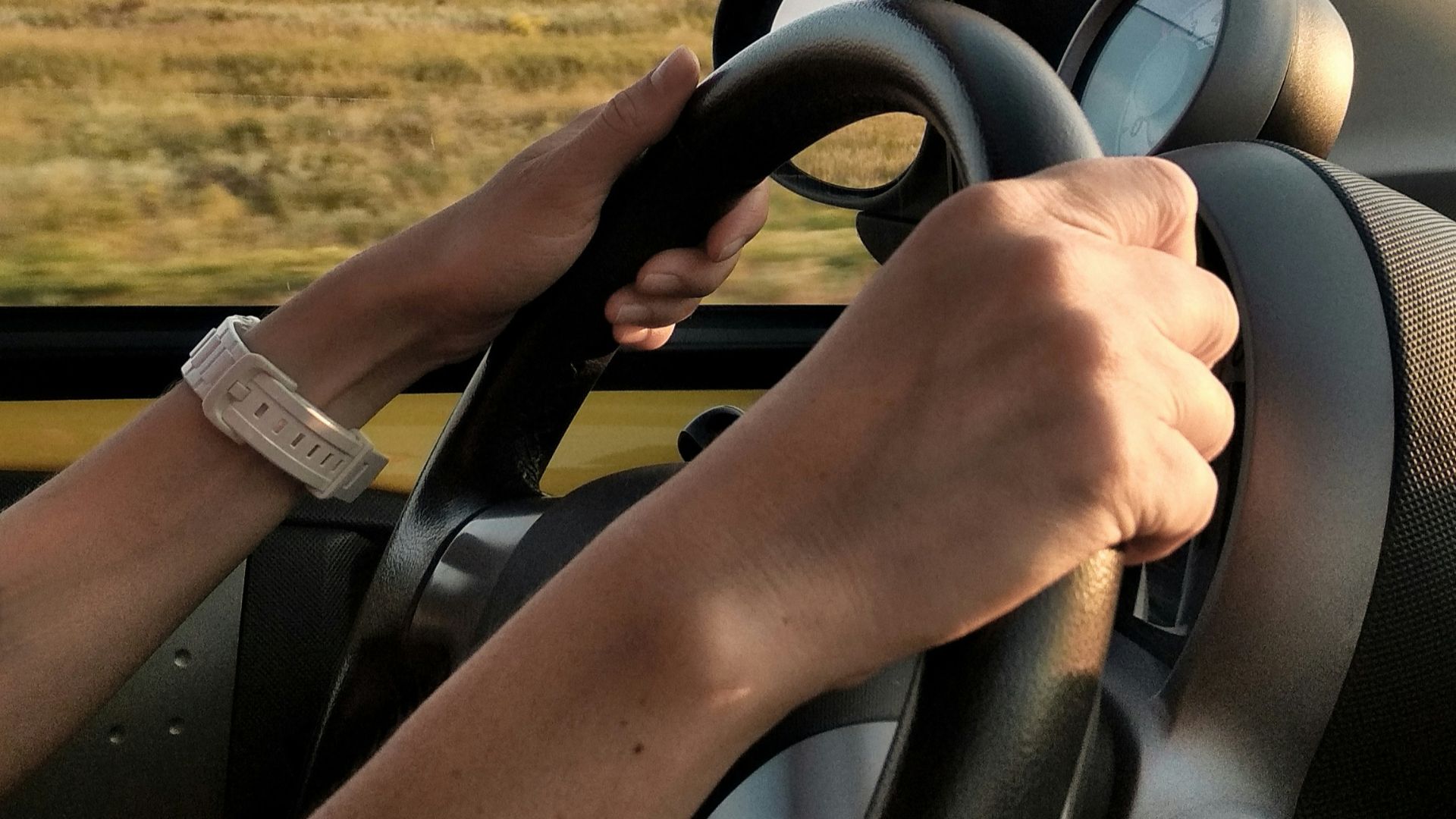 person with white watch driving car