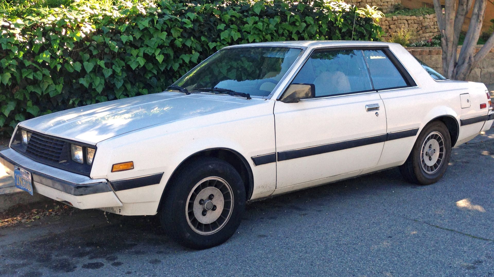 A 1981 Dodge Challenger X. This rebadged Galant Lambda is a facelift model with the redesigned body and a more sporting appearance. Still on original (presumably) California blue-and-gold plates!