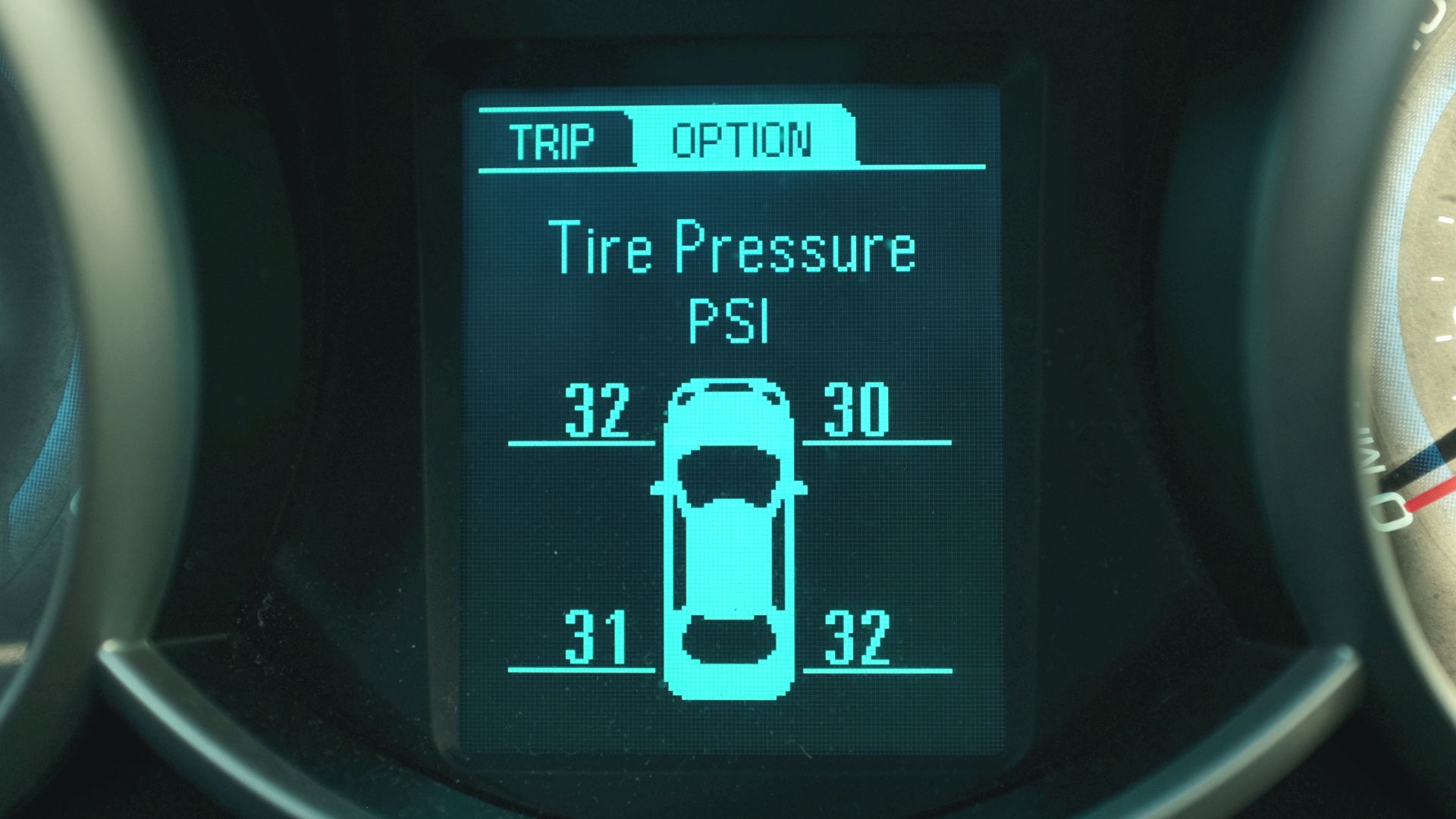 Electronic Driver Information Center (DIC) in a 2013 Chevrolet Cruze displaying pressure measurements reported by the Tire Pressure Monitoring System (TPMS). Measured pressure for each tire is displayed in pounds per square inch (PSI). Pictograph of vehic