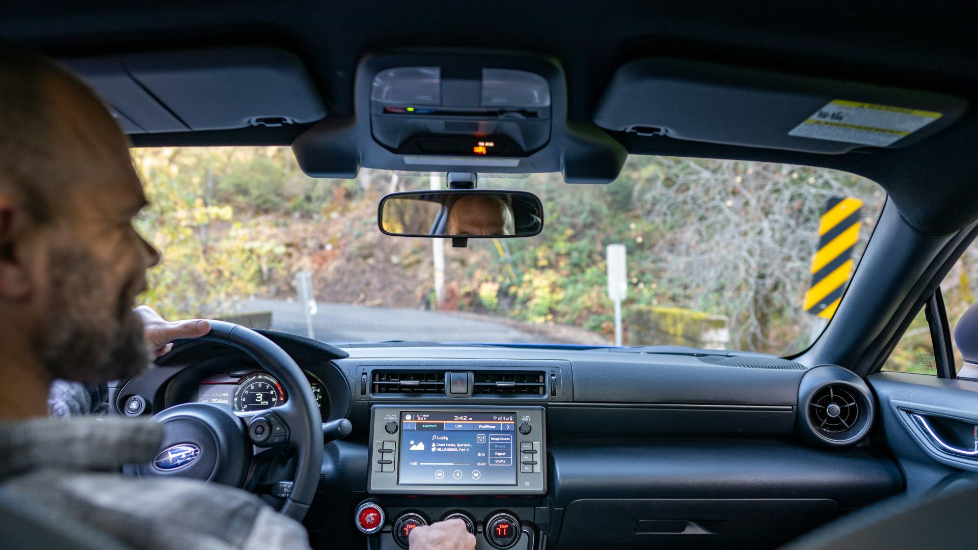 A man driving a car with a gps device in his hand