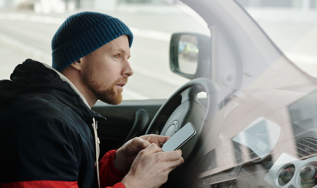 man-holding-his-smartphone-while-driving