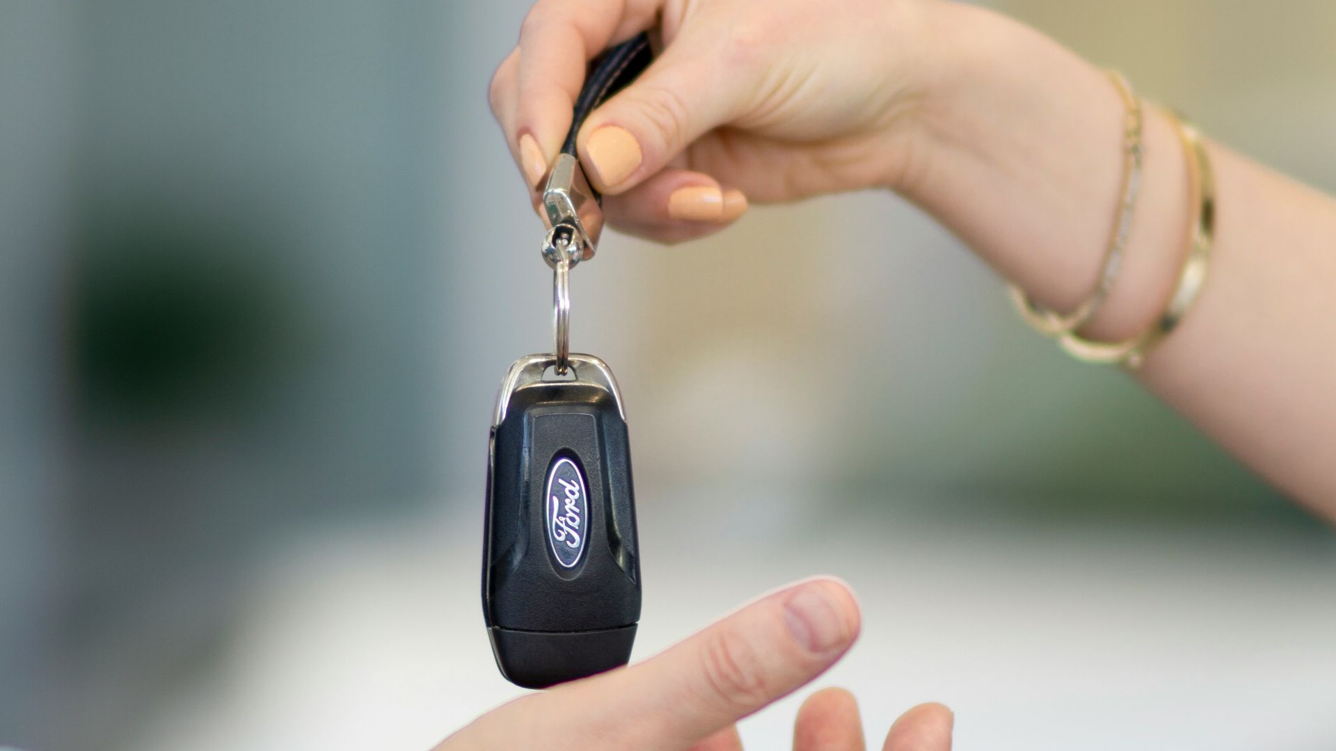 A person handing a car key to another person