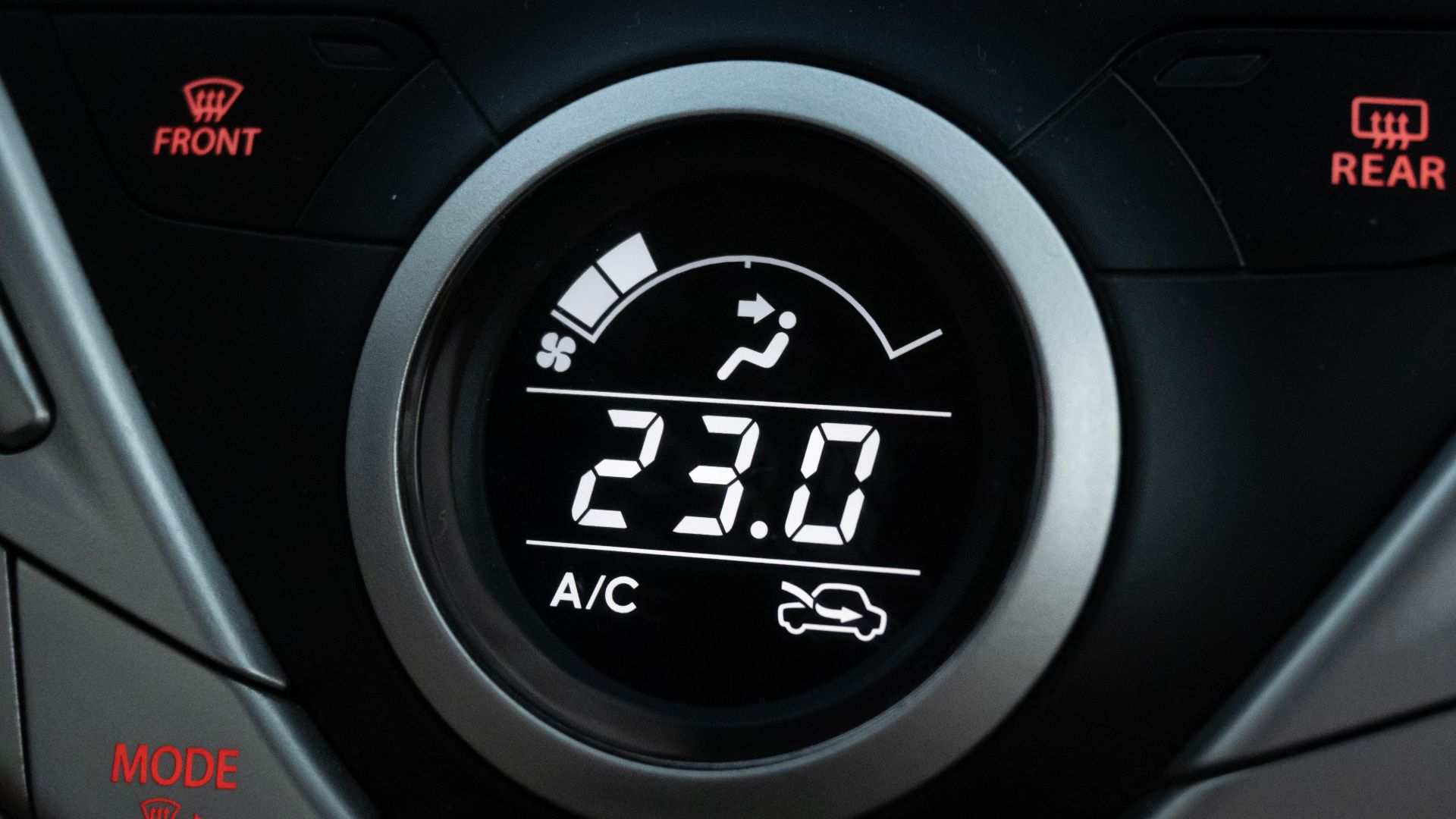 Close-up view of a car climate control system set to 23 degrees Celsius.