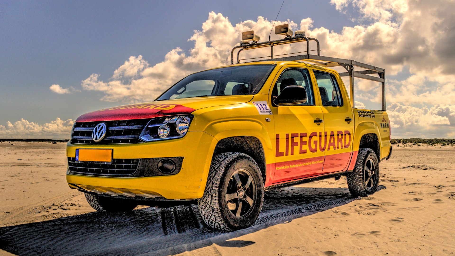 A vibrant yellow lifeguard vehicle parked on a sunny beach, ensuring safety for beachgoers.