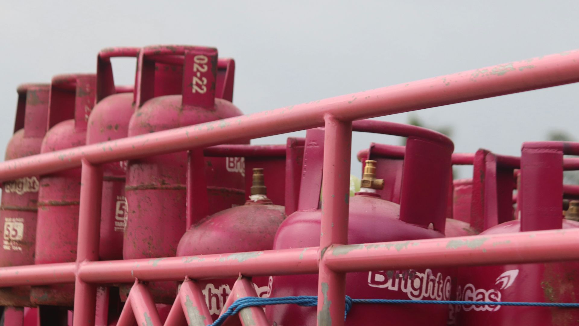 a group of pink gas tanks sitting next to each other