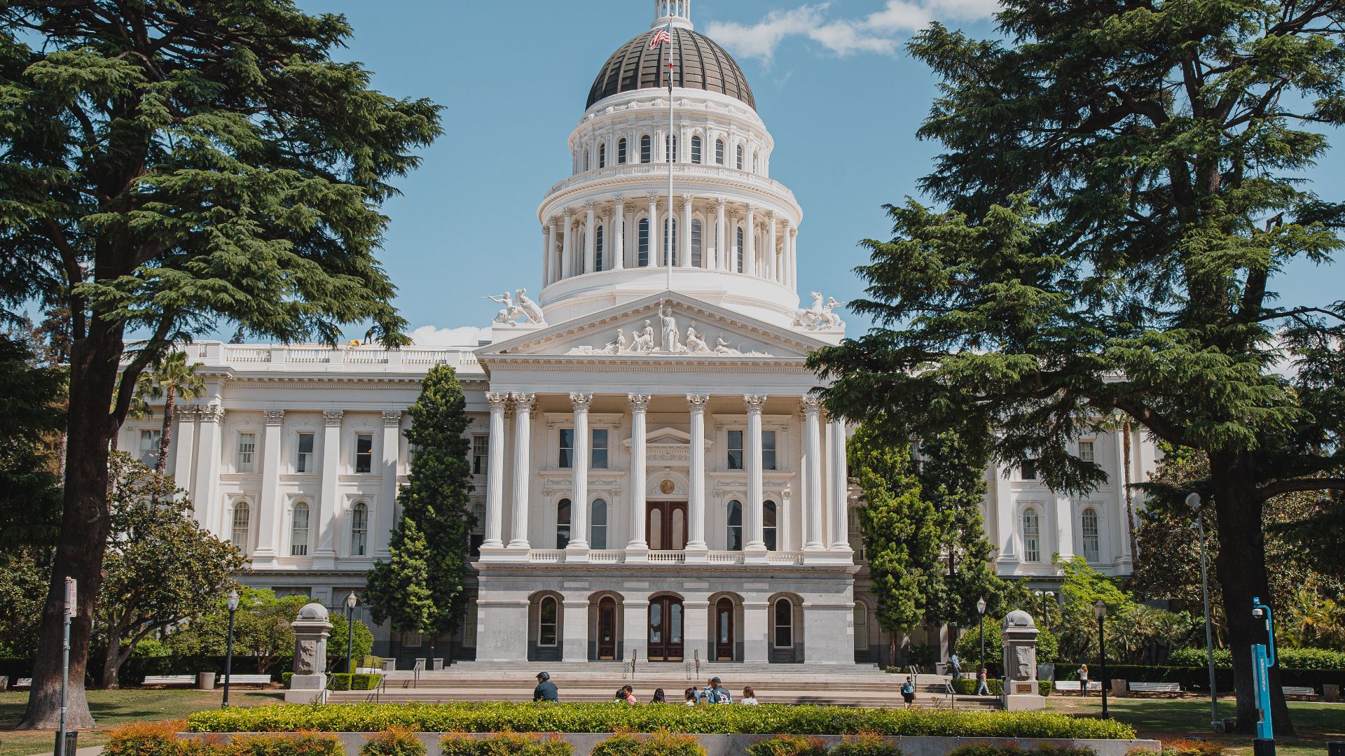 Majestic view of a historical capitol building surrounded by lush greenery.