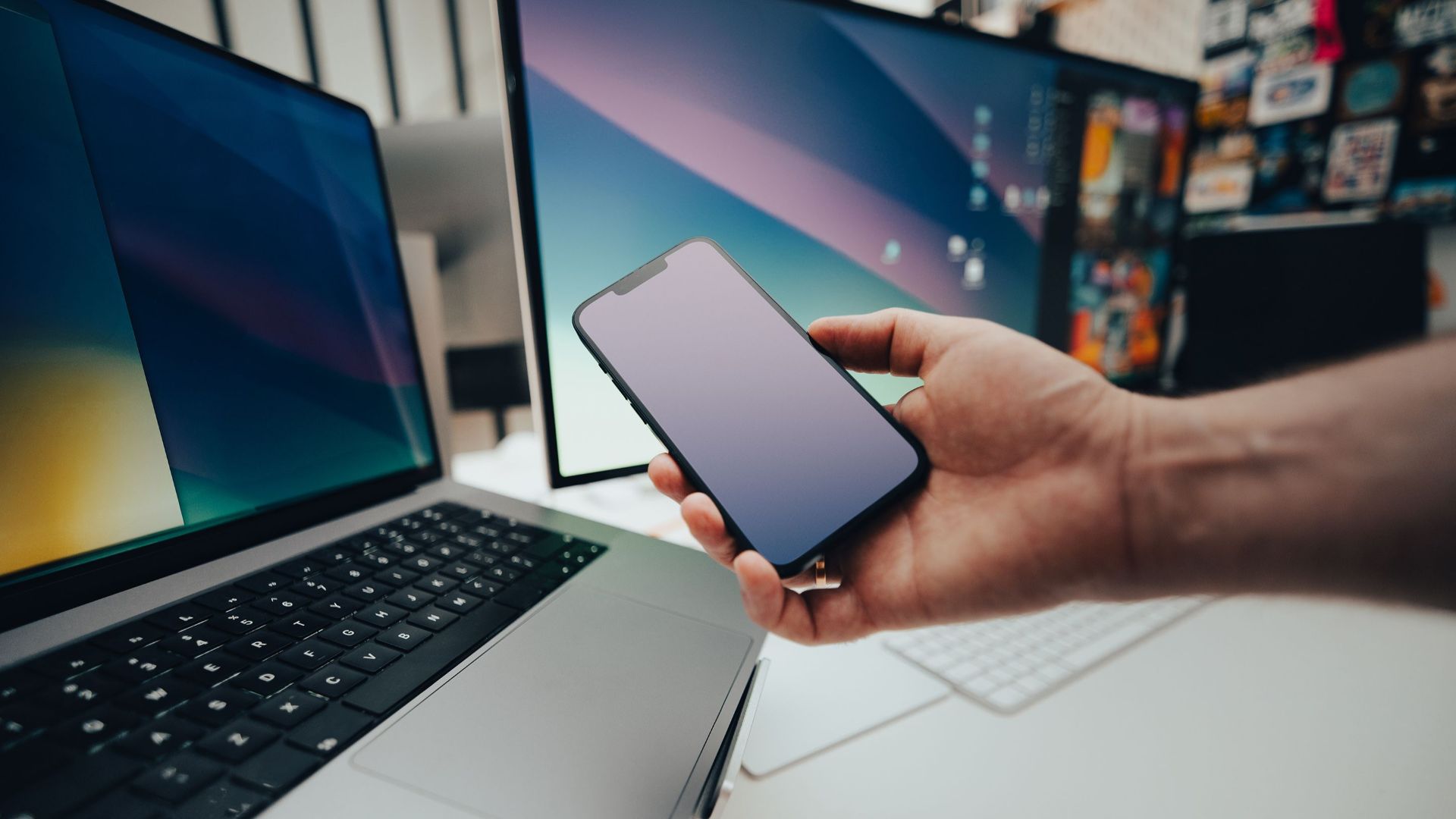 A contemporary workspace with a smartphone and laptop, showcasing modern technology in use.