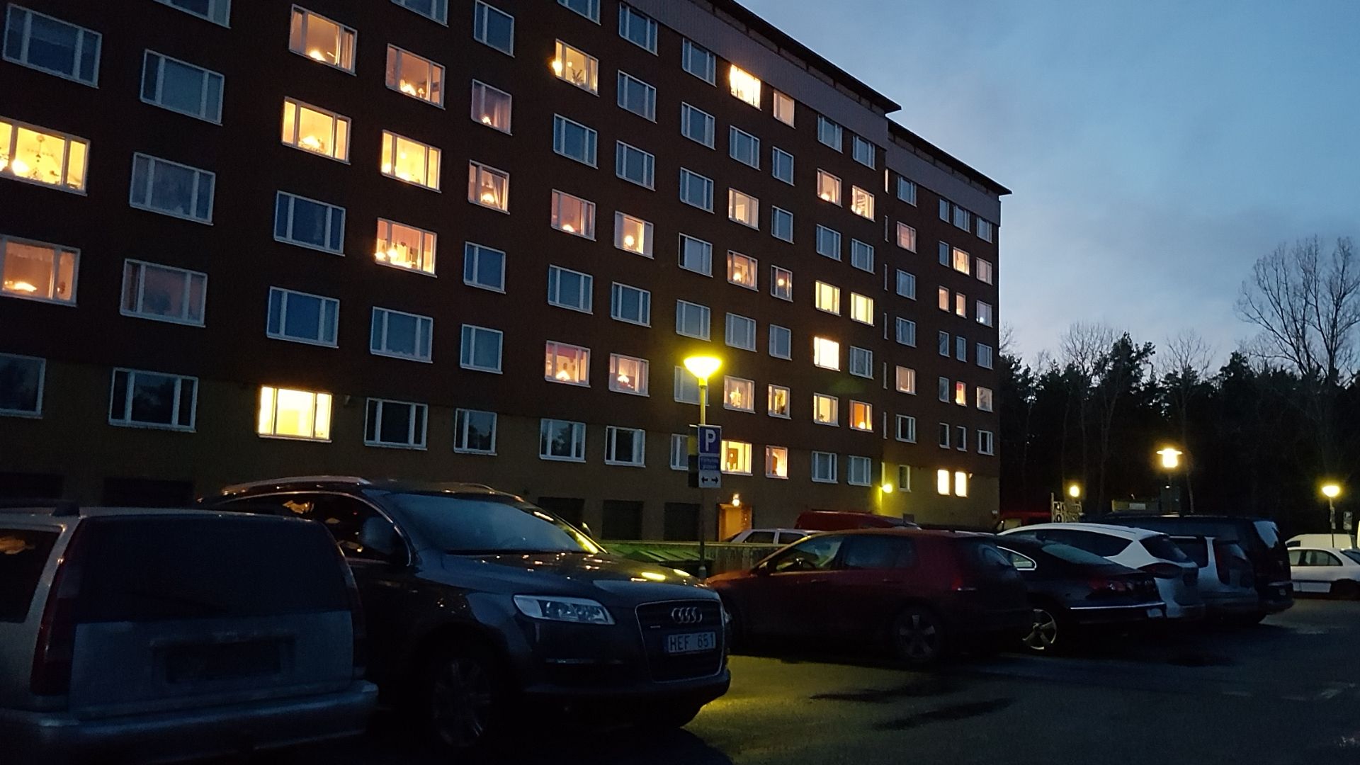 Wohnungsgebäude mit Parkplatz an einem dunkelen Nachmittag in Schweden