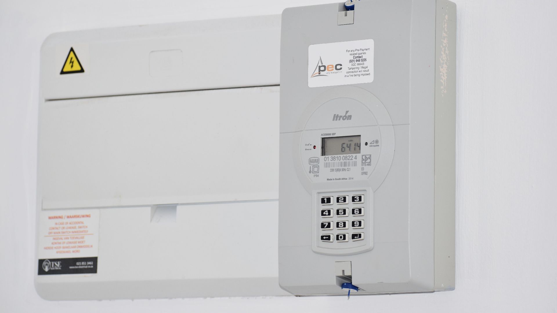 Electrical meter and fuse box on a white wall in Cape Town, South Africa, for energy monitoring or billing.