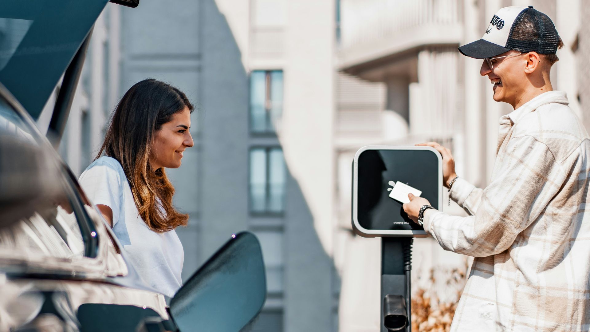 a man and a woman are charging their cars