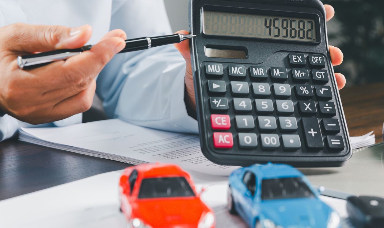 Businesswoman signing car insurance document or lease paper. Writing signature on contract or agreement. Buying or selling new or used vehicle. Car keys on table. Warranty or guarantee.