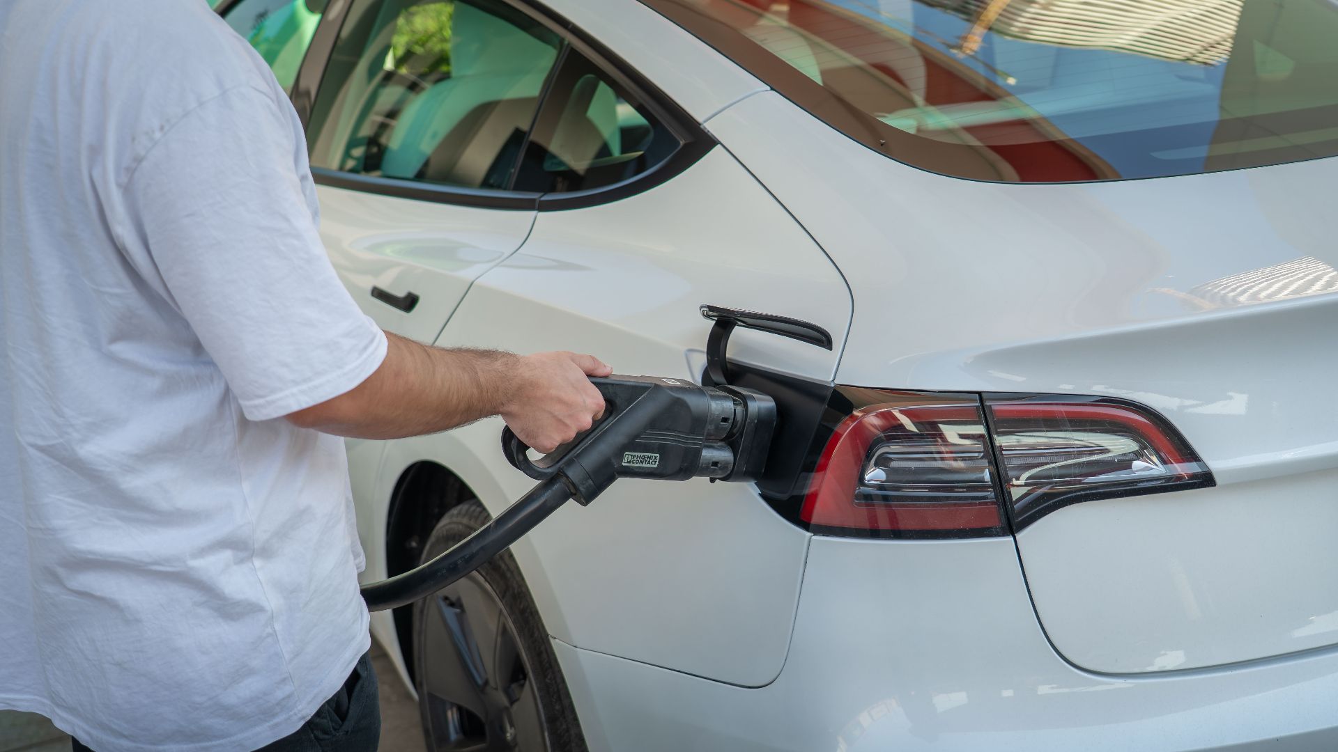 Electric car being charged at a station, highlighting eco-friendly transportation.