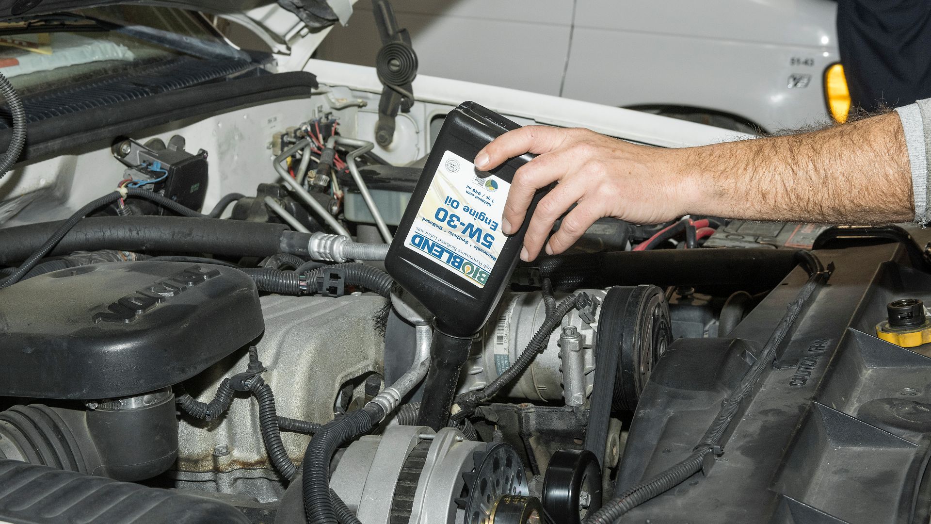 A new bio-based synthetic engine oil is added to one of the vehicles that Armstrong is using to assist in performance testing of the new product.