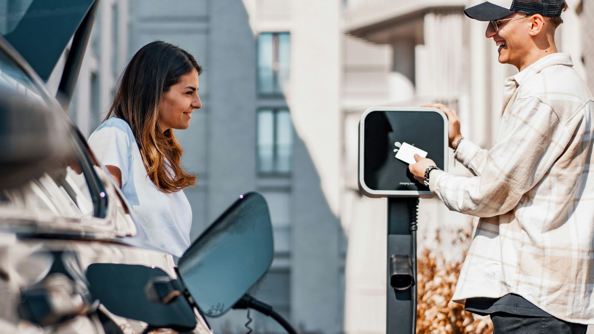 a man and a woman are charging their cars