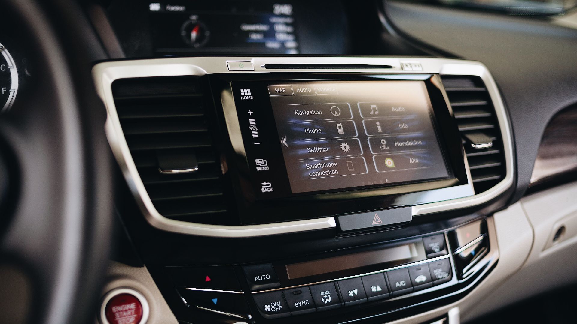 Close-up view of a modern car's infotainment display showing navigation and smartphone settings.