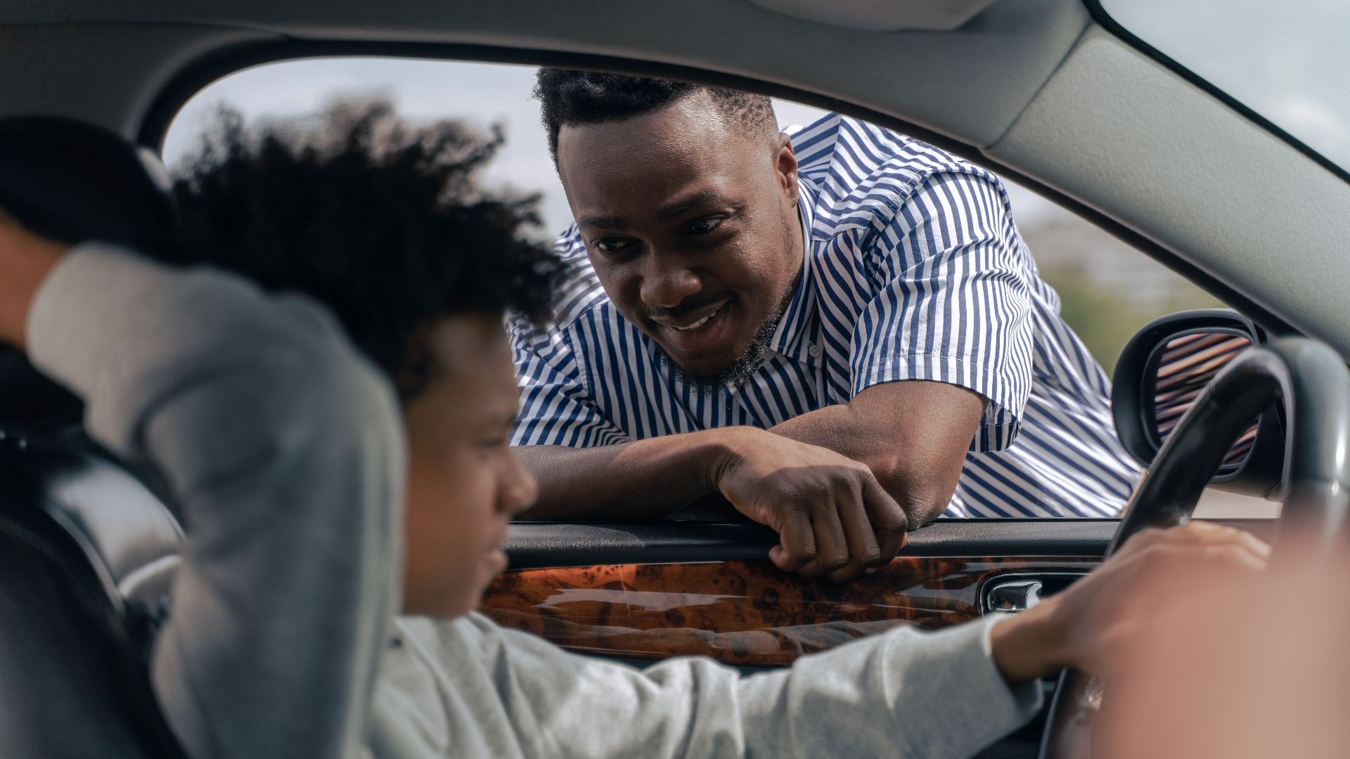 Father teaching his son how to drive, bonding and learning together.