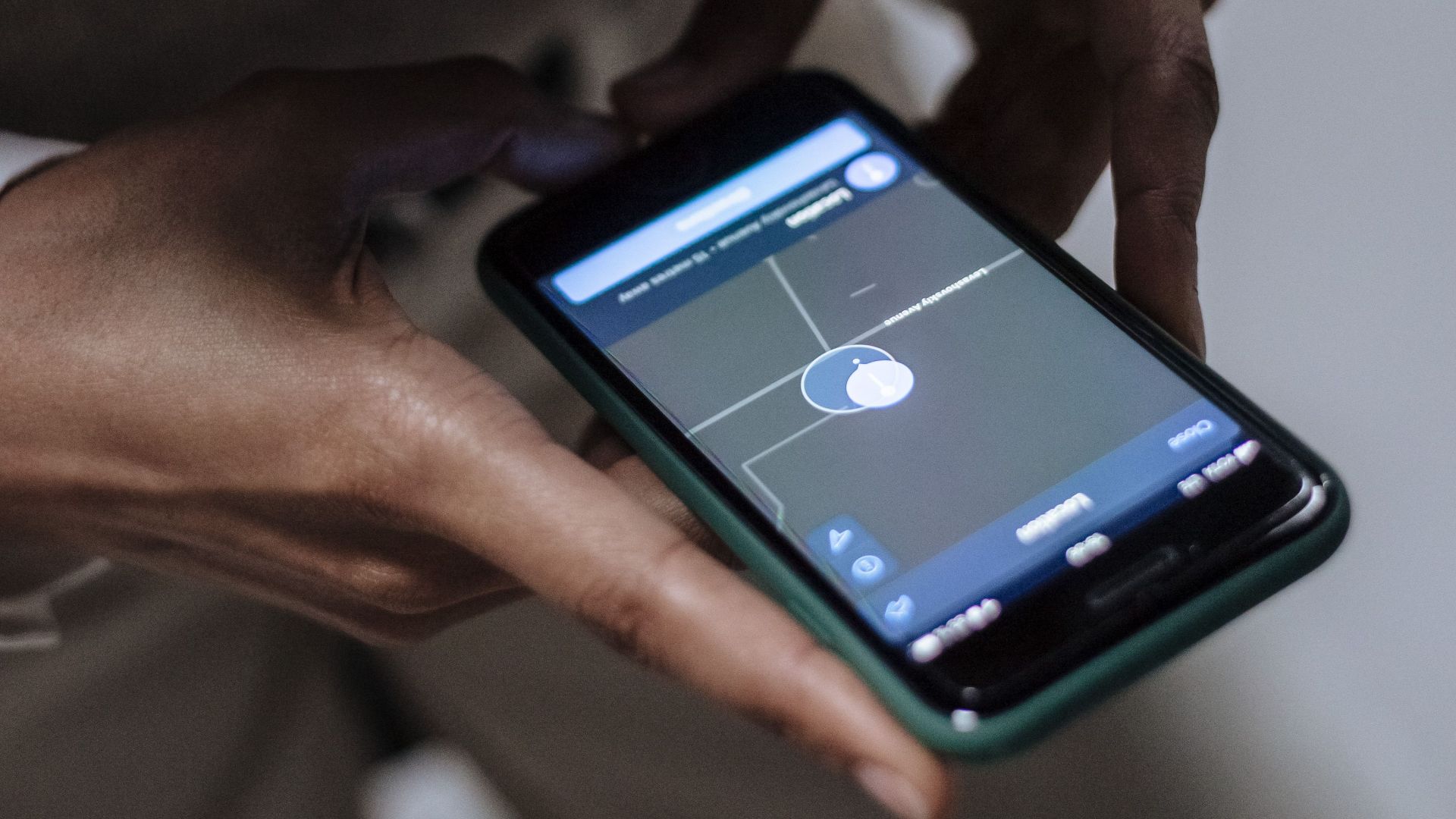Close-up of a woman holding a smartphone with GPS navigation displayed, emphasizing technology and connectivity.