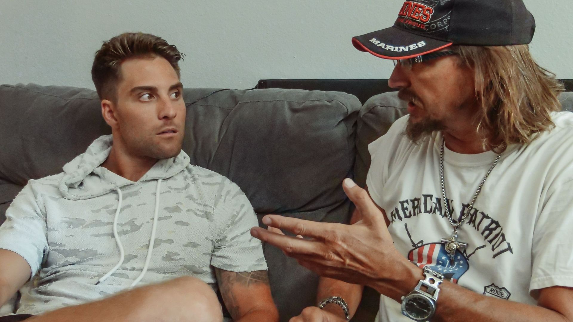 Father and son engaging in a deep conversation while sitting on a cozy sofa indoors.