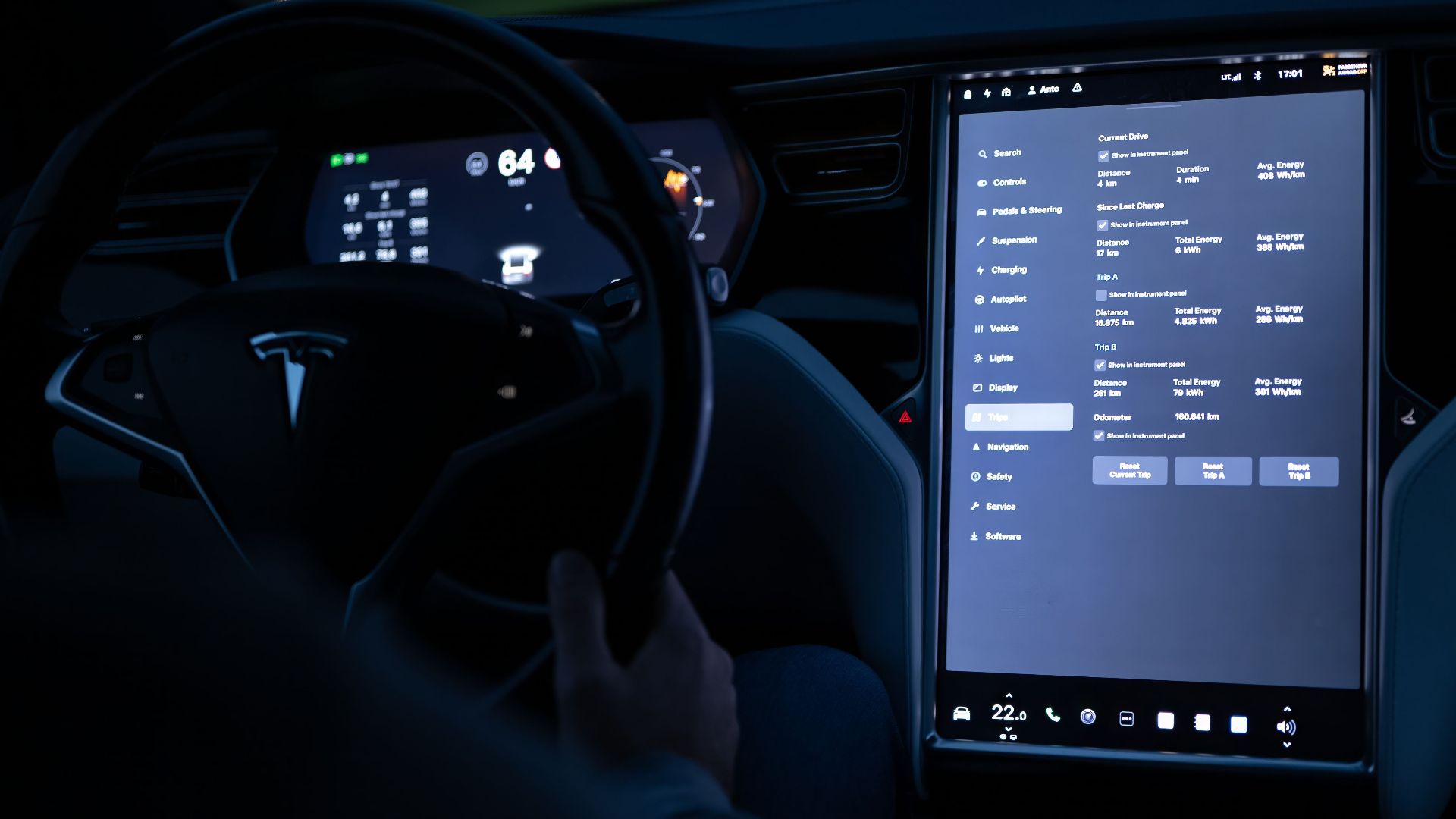 Interior view of an electric car showing advanced touchscreen and steering wheel at night.