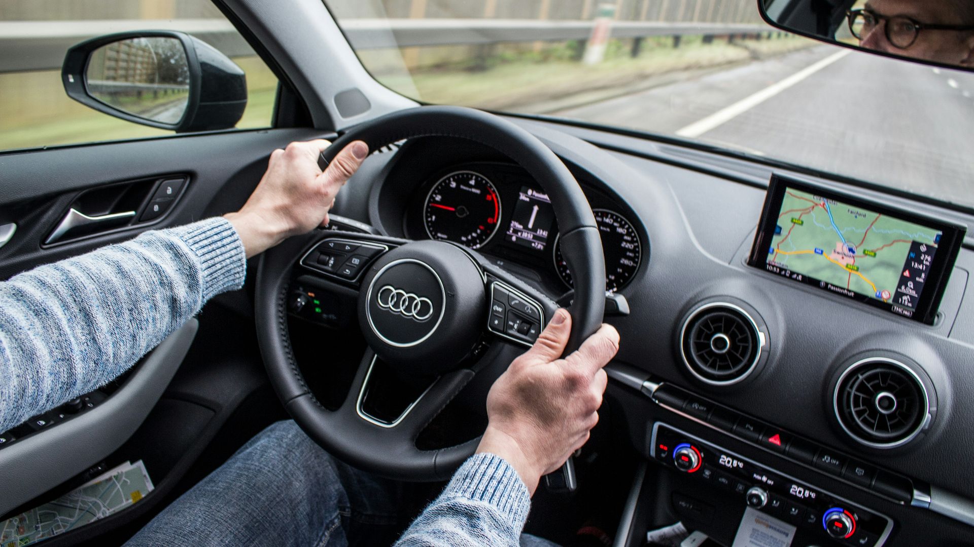 man driving Audi car on asphalt road