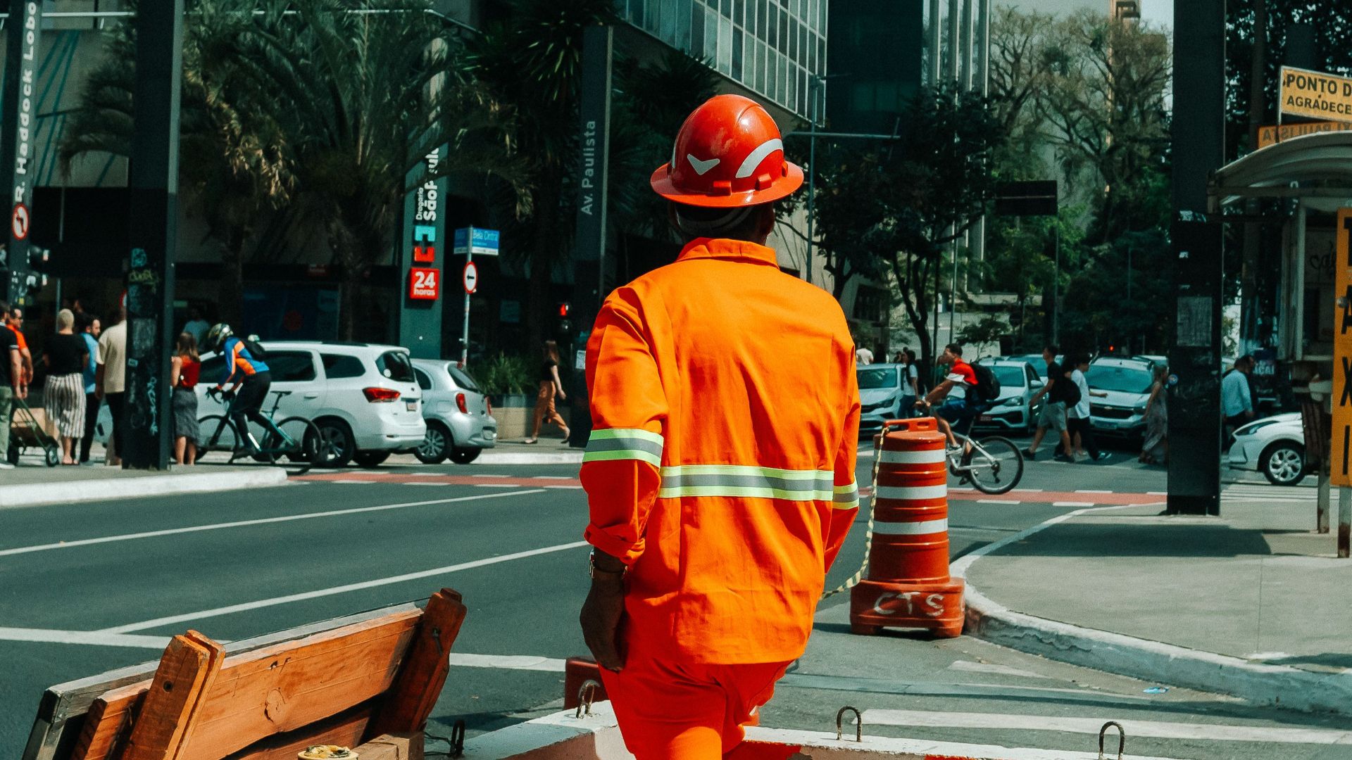 Urban scene in São Paulo with construction worker and bustling street life.