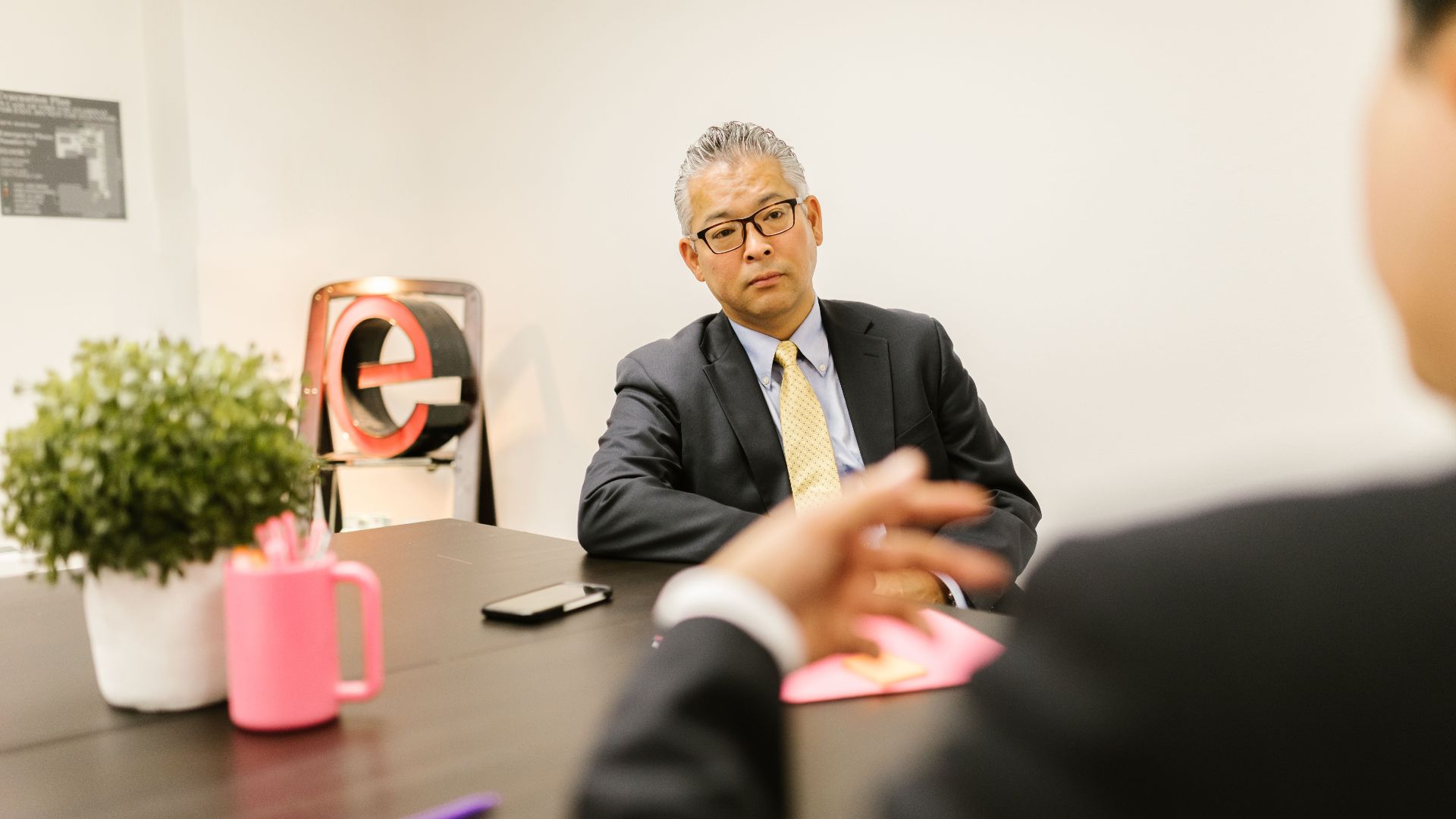 Business professionals in a formal meeting discussing ideas in a modern office environment.