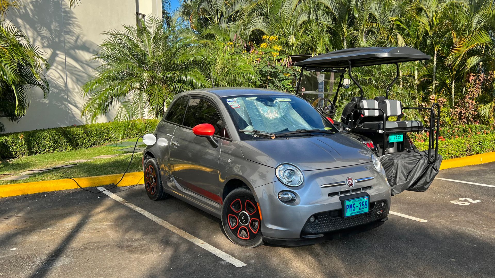 Fiat 500e and electric golf cart charging from a residential 110-120VV outlet. Jacó, Puntarenas Costa Rica