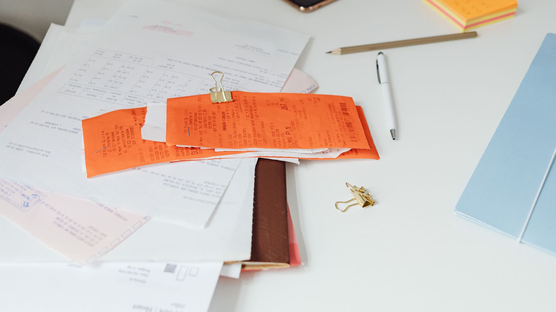 Close-up of a tidy desk with receipts, documents, and office stationery for business organization.