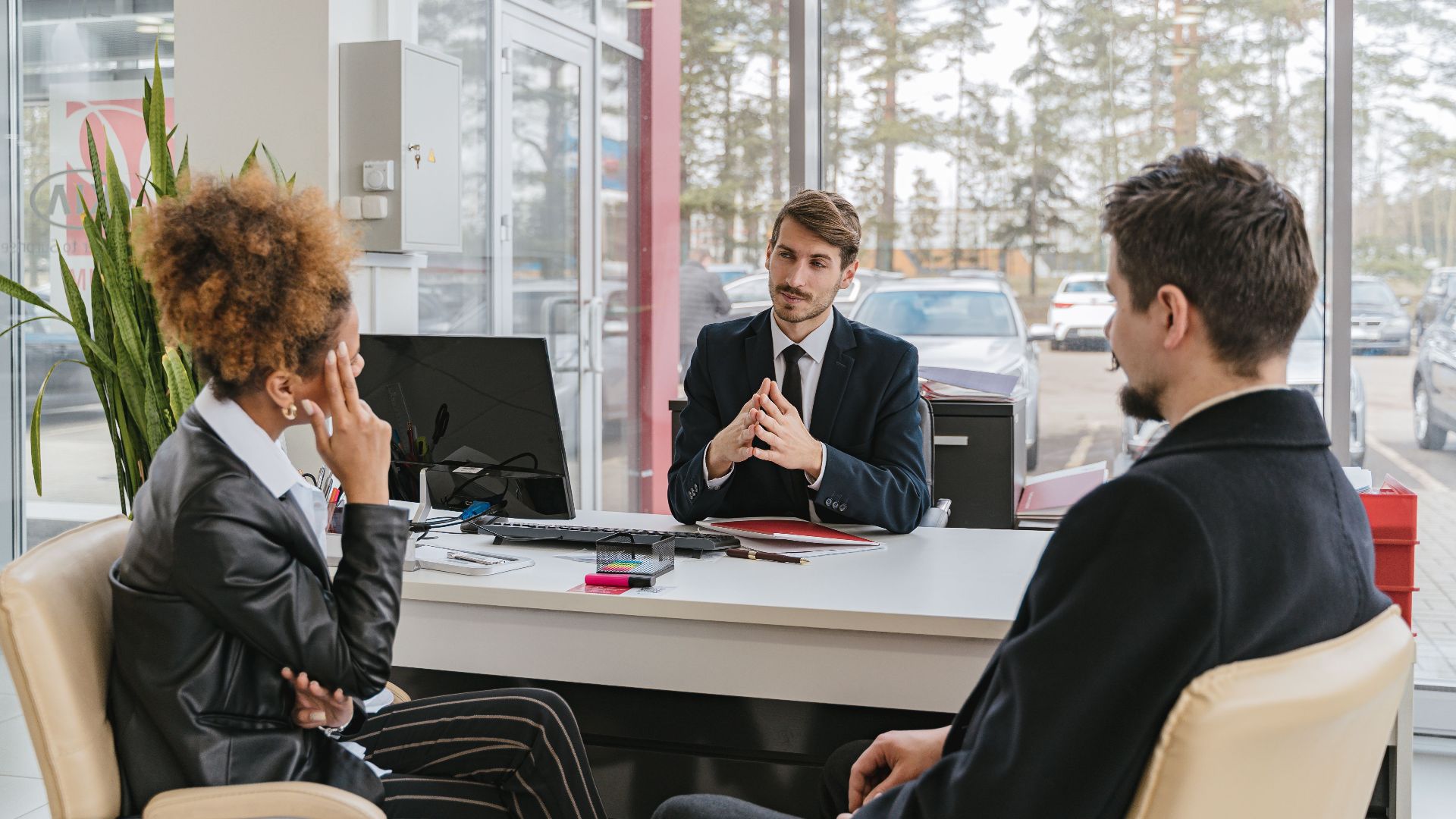 Three adults in a modern office setting having a professional business meeting.
