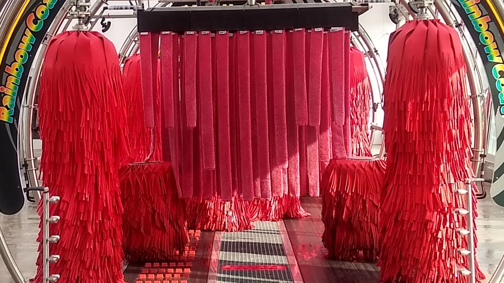 This is a photo of the point of view of a car entering on to the belt of a Tommy's Express car wash tunnel in Orland Park, Illinois, in the United States. This is a photo of the inside of the tunnel, and the wash is not currently operating in the photo, a