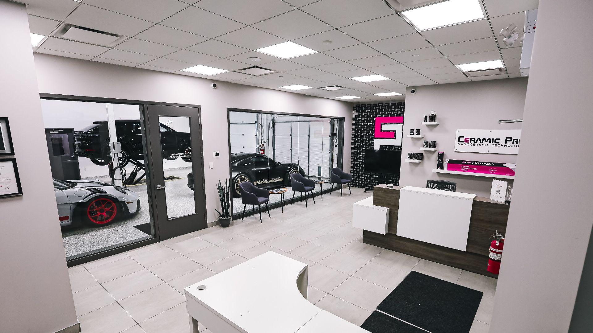 Spacious and modern car salon with luxury cars in a pristine interior setting.