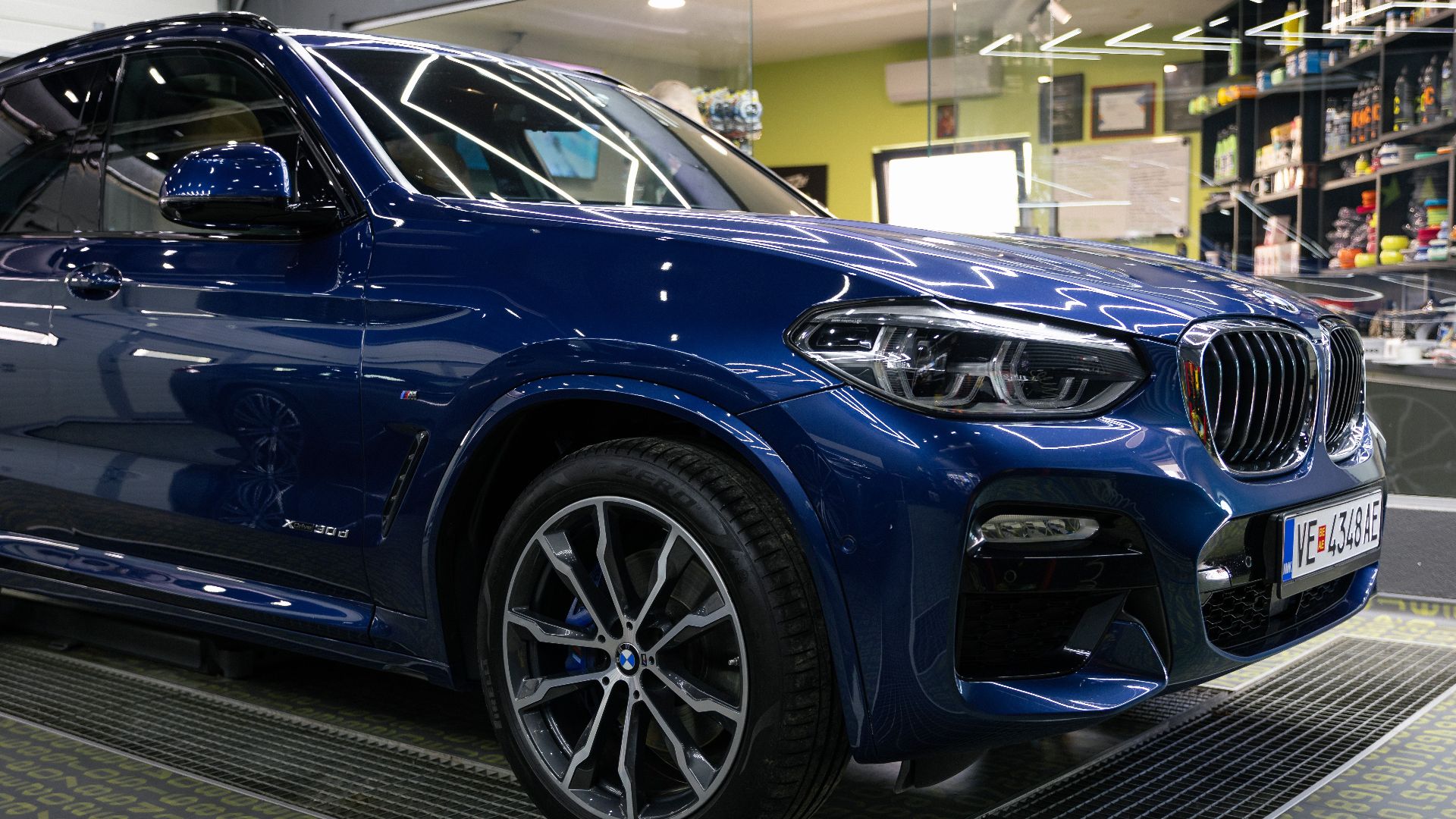Detailed image of a luxury blue SUV parked in a modern garage with sleek design elements.