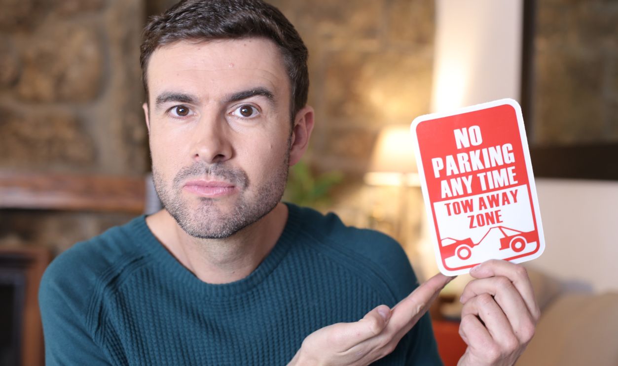 Man holding no parking sign