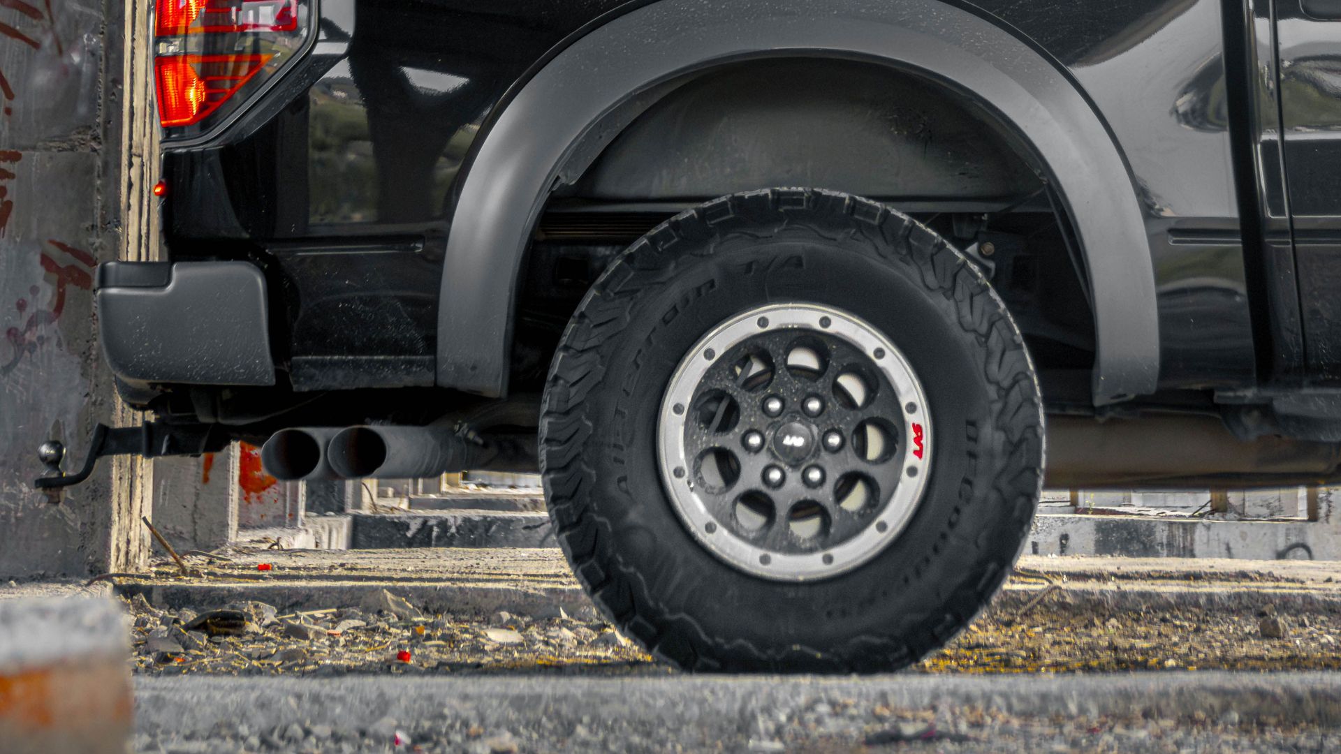 Black pickup truck parked in a concrete structure, showcasing urban-industrial contrast.