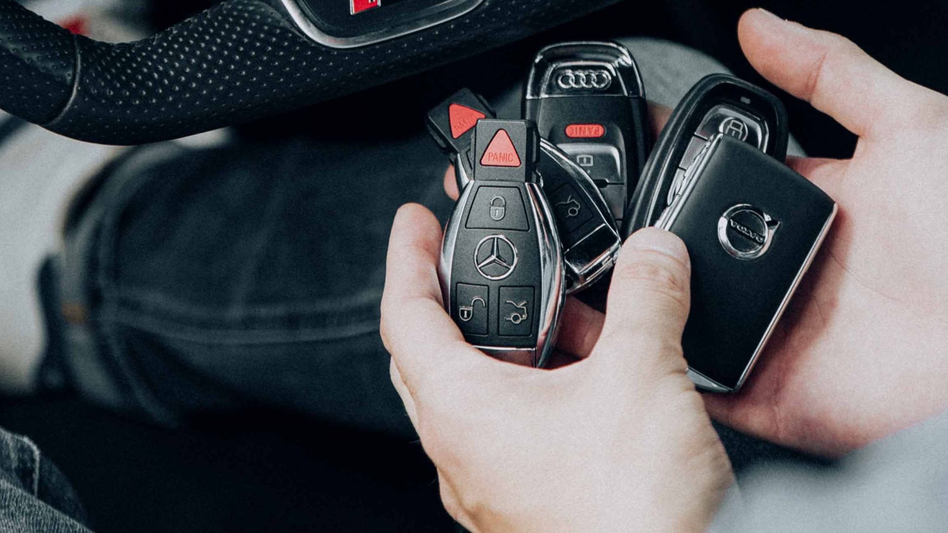 Detailed view of Audi car interior showcasing steering wheel and key fobs in hand for luxury vehicle lifestyle.