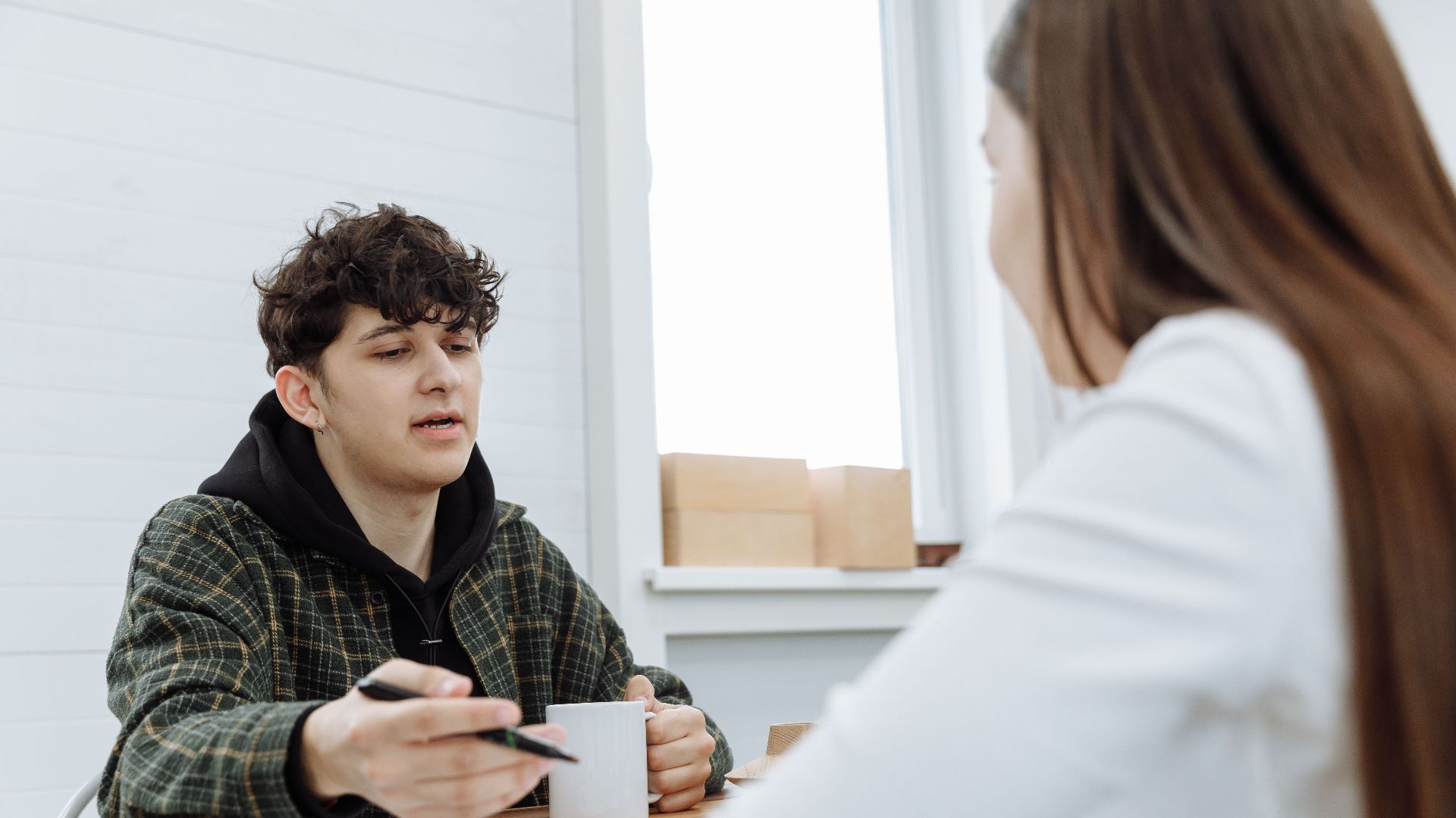 Two colleagues having a relaxed discussion in a modern office space.