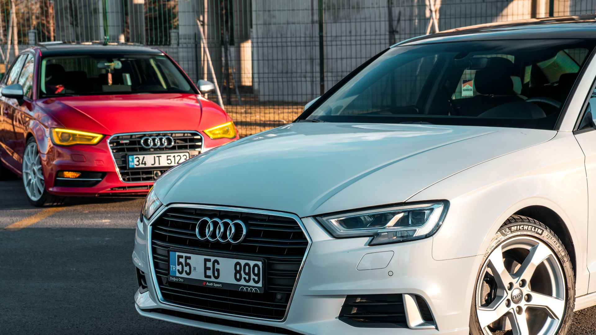 Two Audi cars parked in the daylight, showcasing sleek design and style.