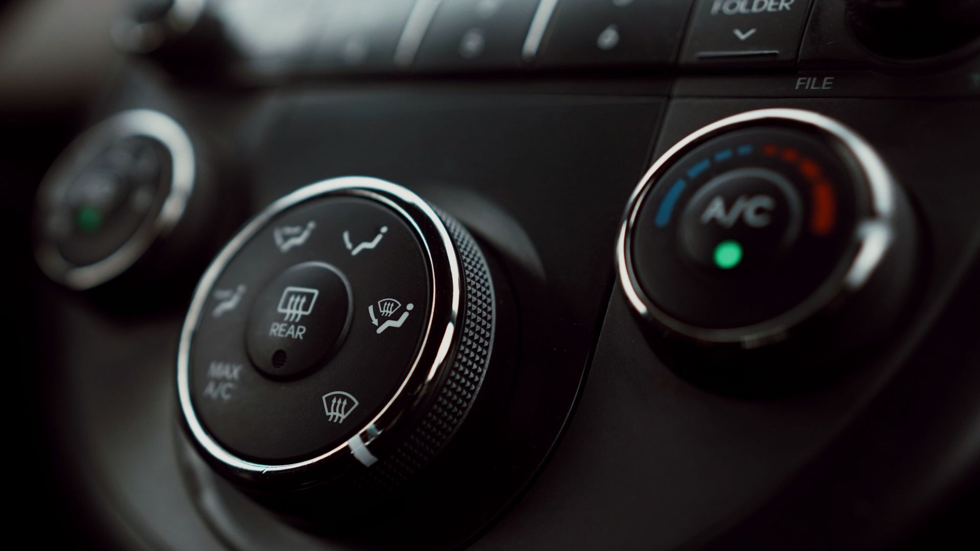 Detailed close-up of car dashboard air conditioning controls with focus on buttons and dials.
