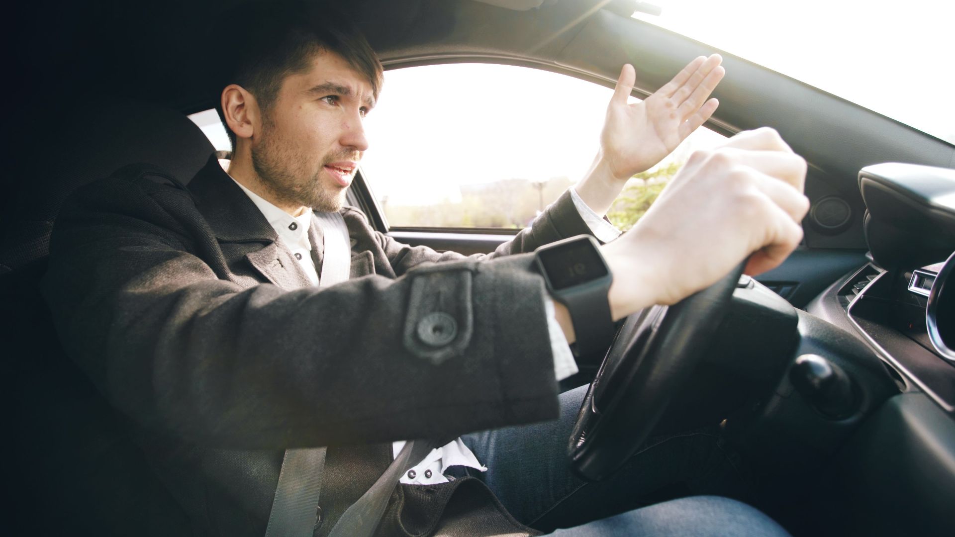 Man showing frustration while driving a car, highlighting road rage issues.