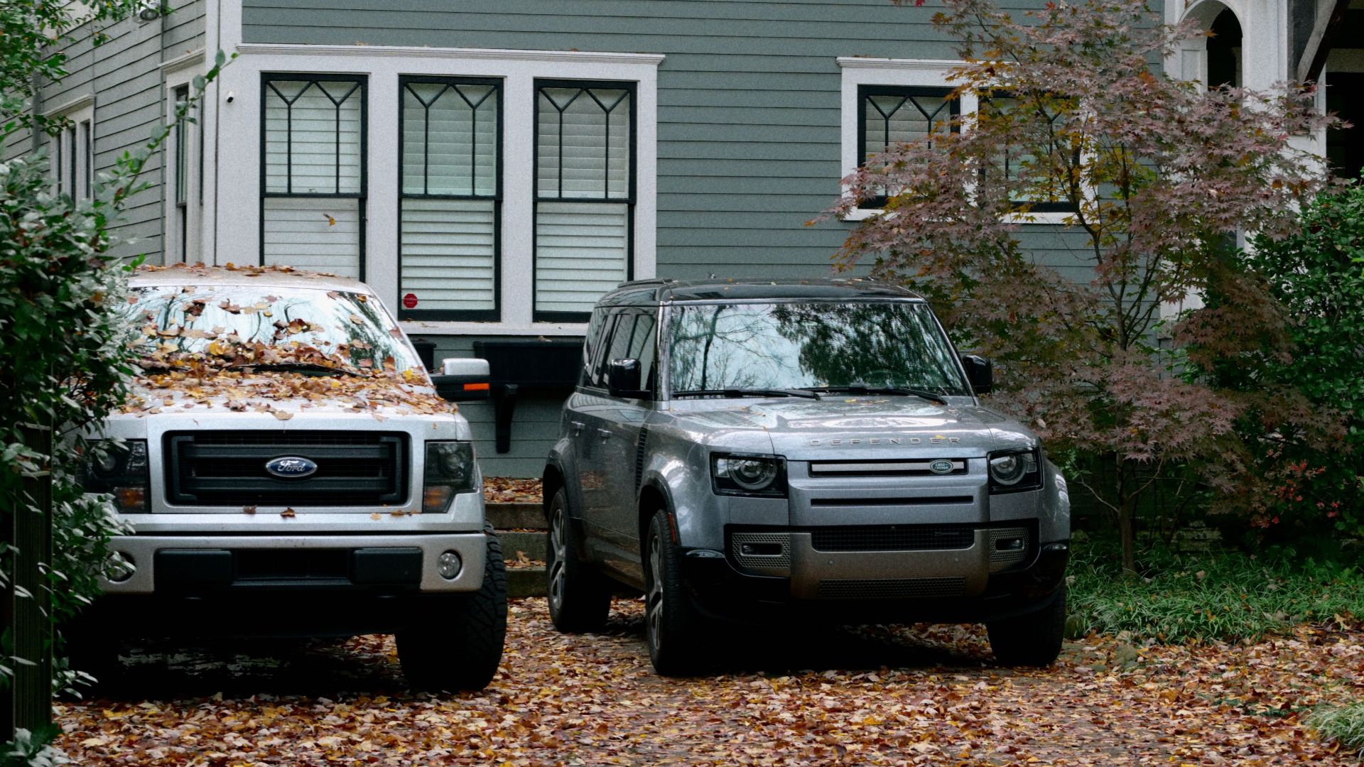 Charming historic home in Atlanta with parked cars amidst vibrant autumn foliage.