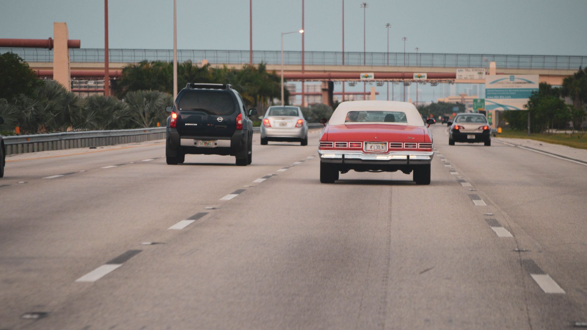 Highway traffic scene with classic car in Miami, Florida, showcasing urban travel atmosphere.