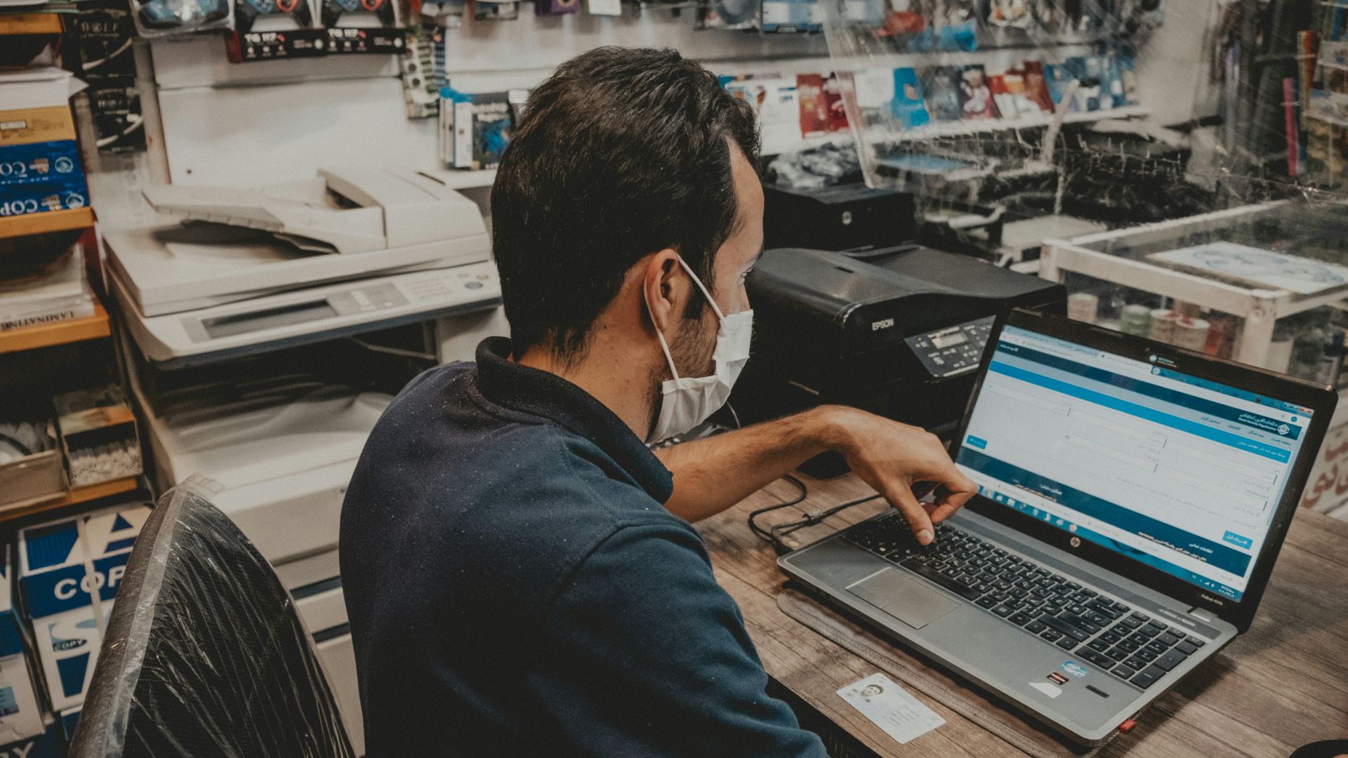 man in blue shirt using black laptop computer
