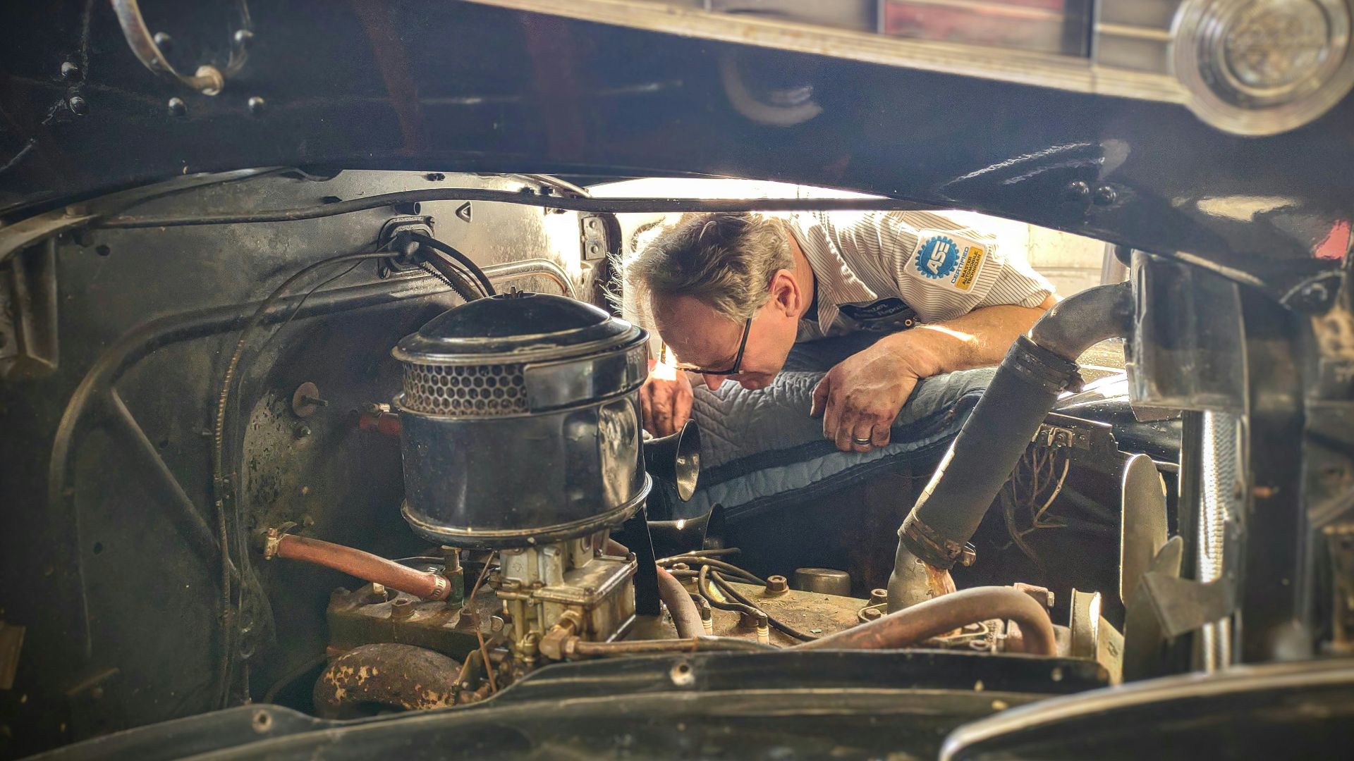 a man working on a car engine in a garage