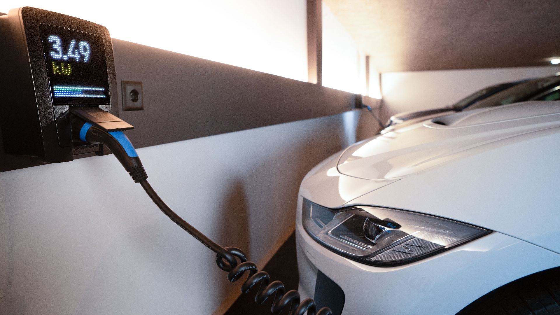 White electric car charging at indoor station, emphasizing sustainability and efficiency.