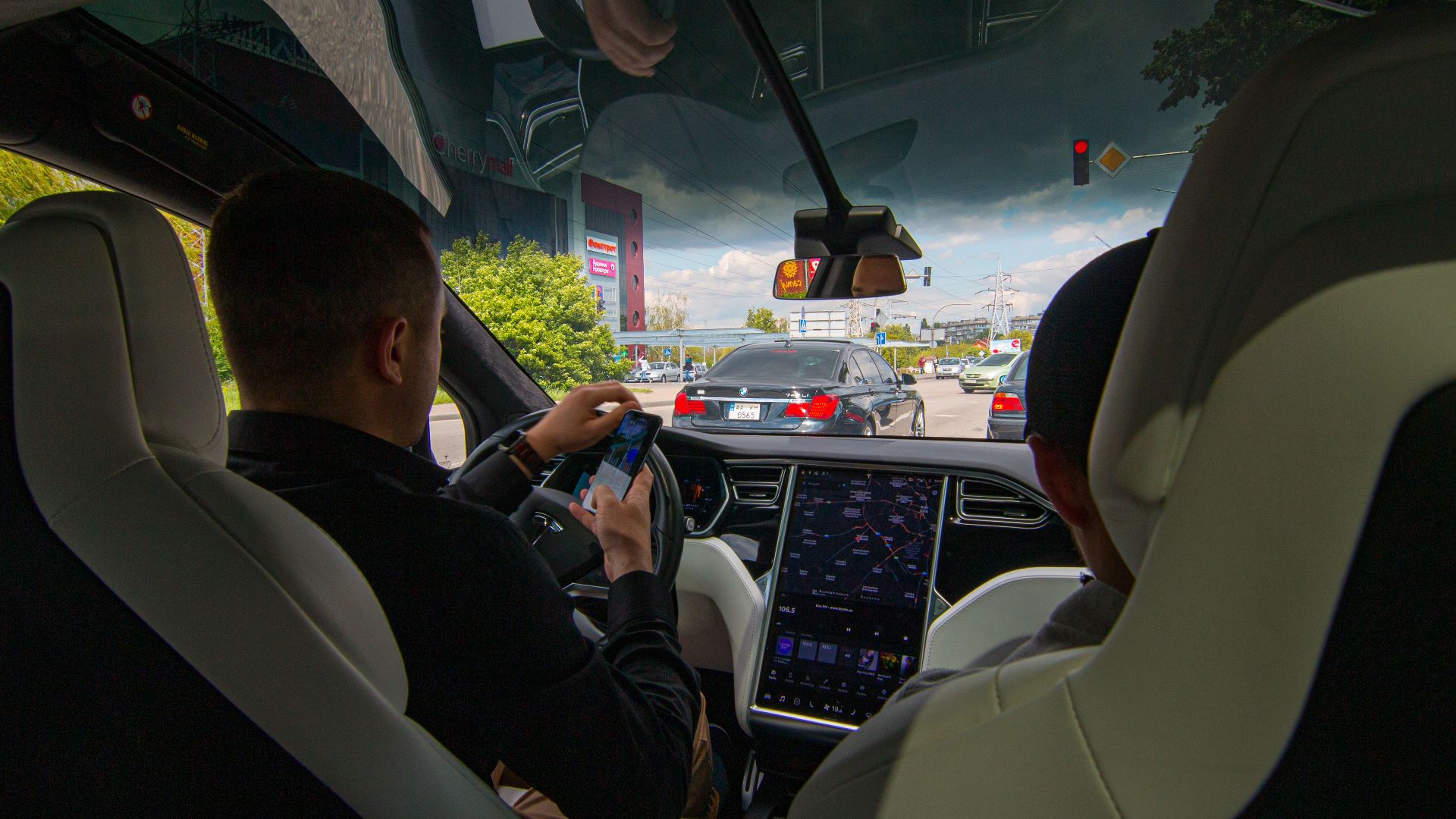 Inside a Tesla vehicle in city traffic, showcasing modern technology and urban driving.