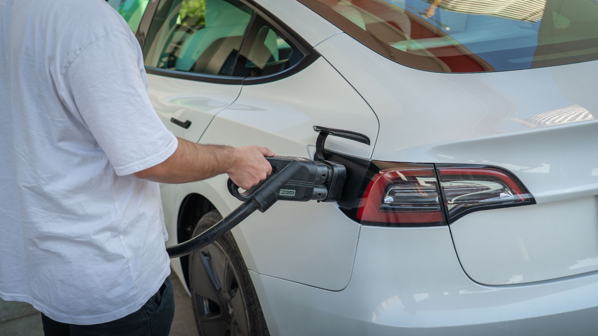 Electric car being charged at a station, highlighting eco-friendly transportation.