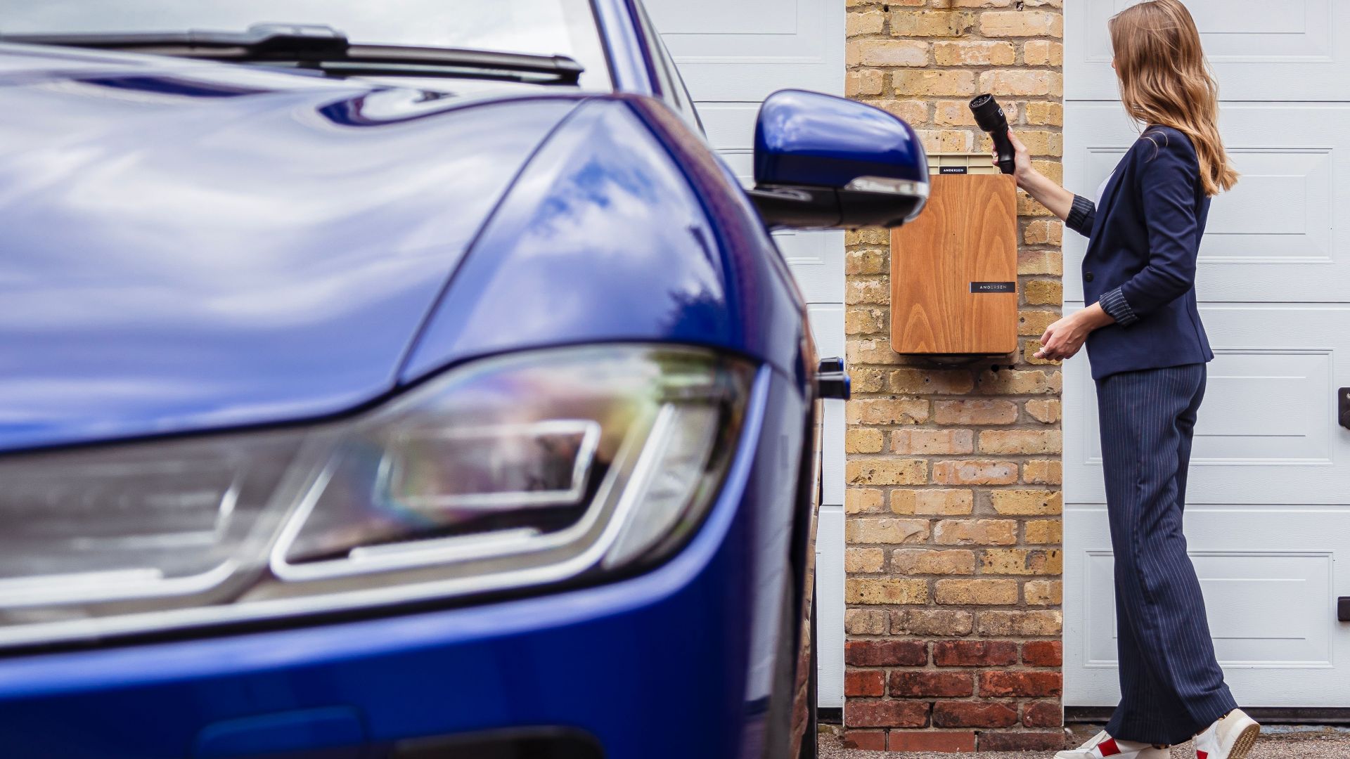 Woman charging an electric car at a home station, promoting sustainability.