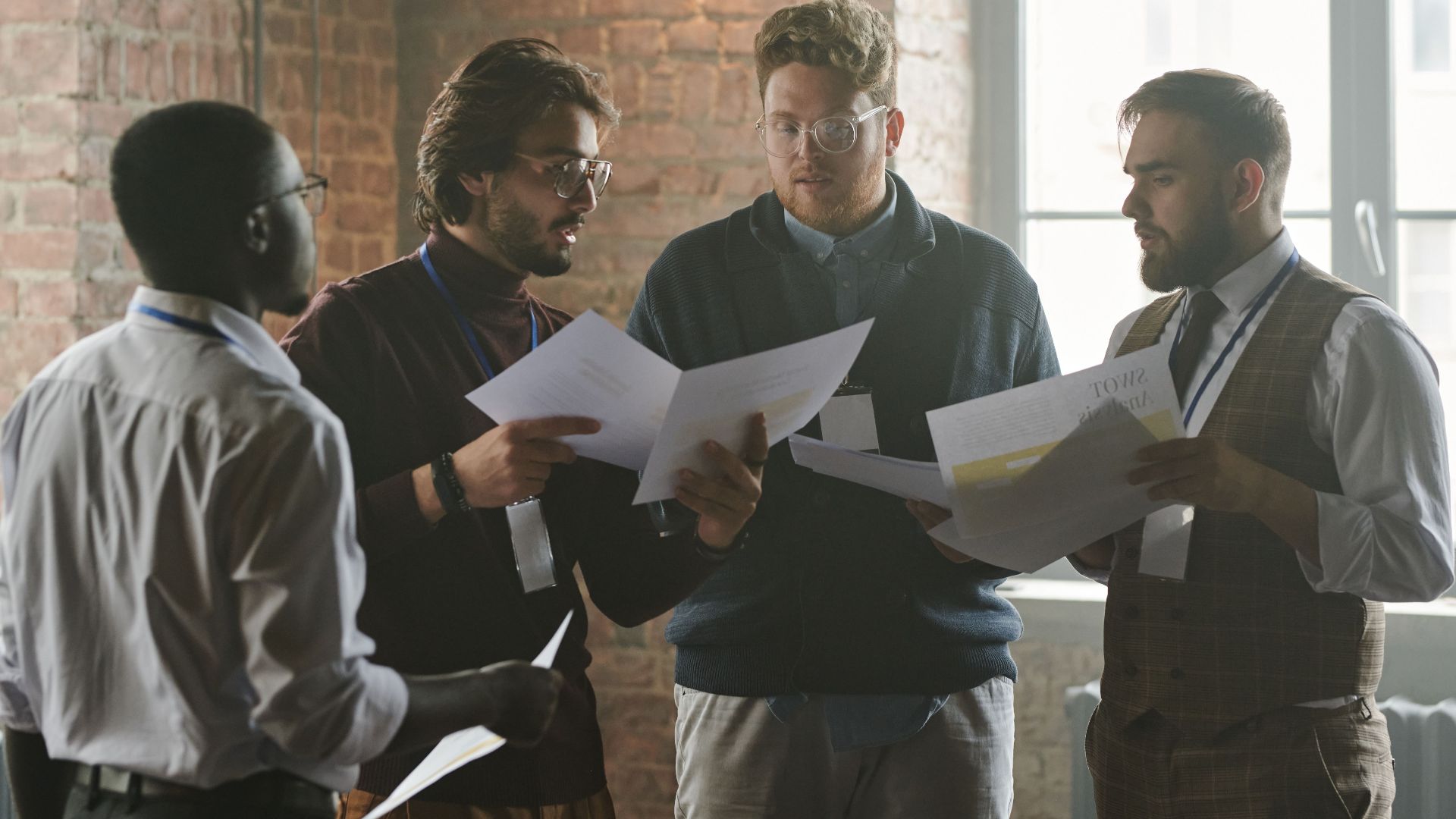 Young professionals discussing documents during a team meeting in a stylish office setting.
