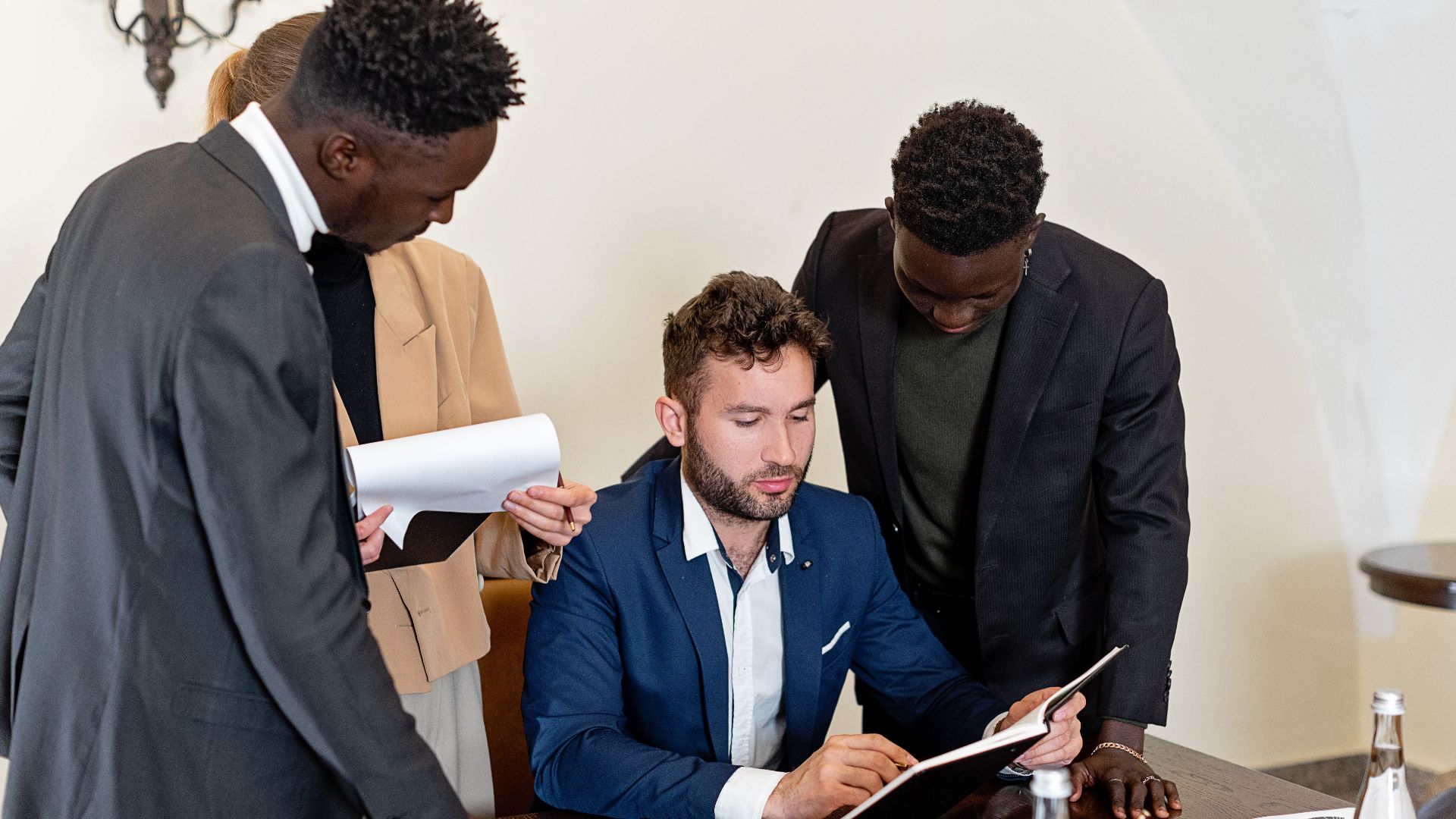 A diverse team collaborating in an office meeting, focusing on documents and teamwork.