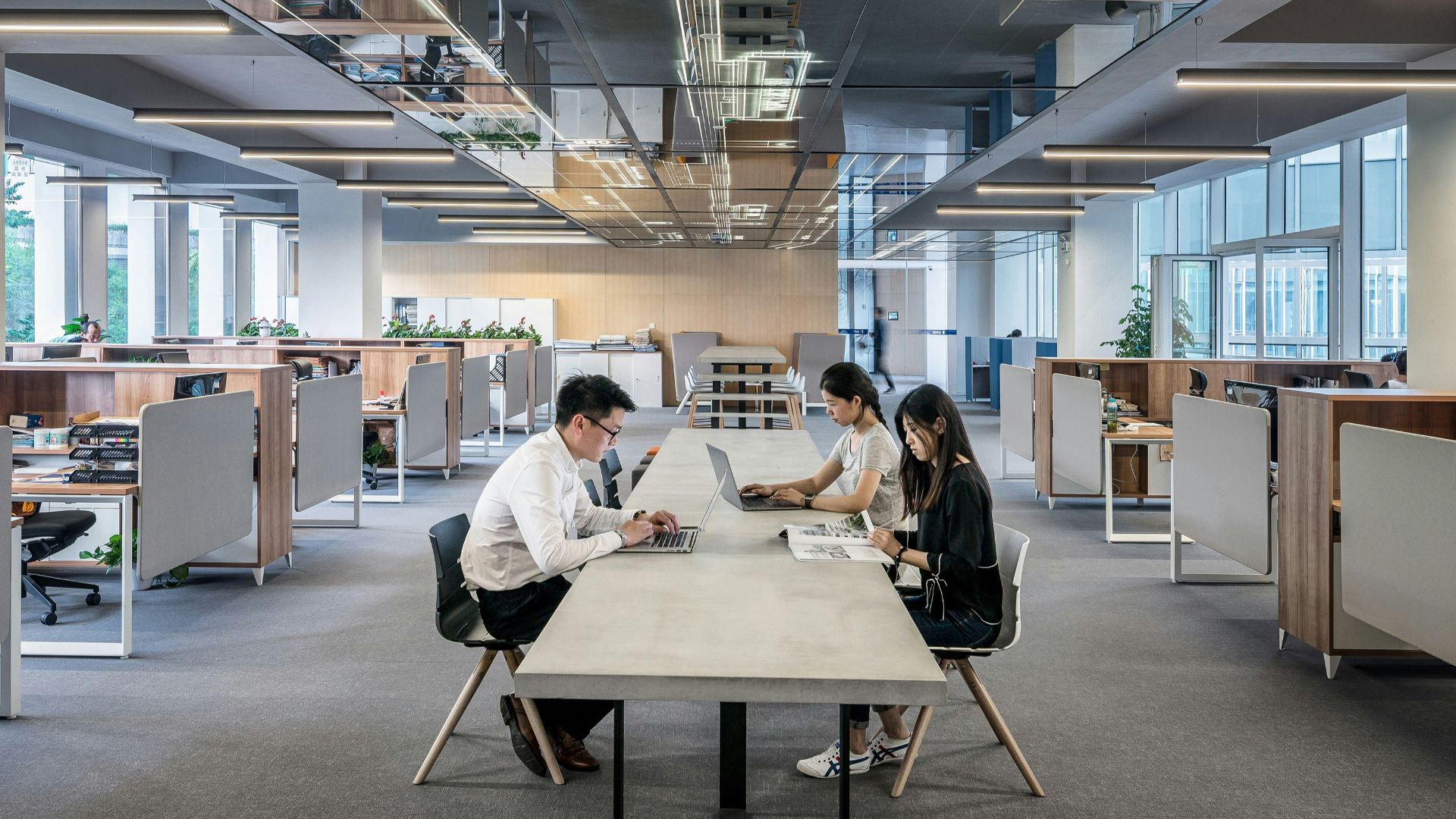 three people collaborating in open office